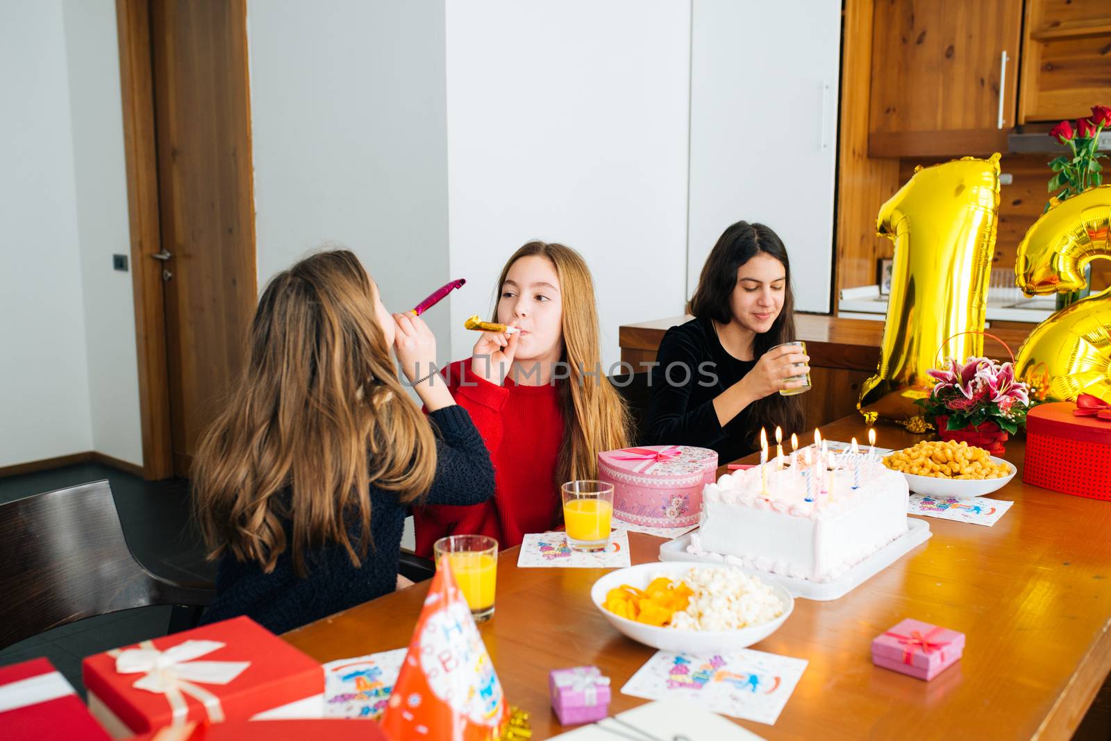 Group of kids celebrate birthday together and blowing in the whistles