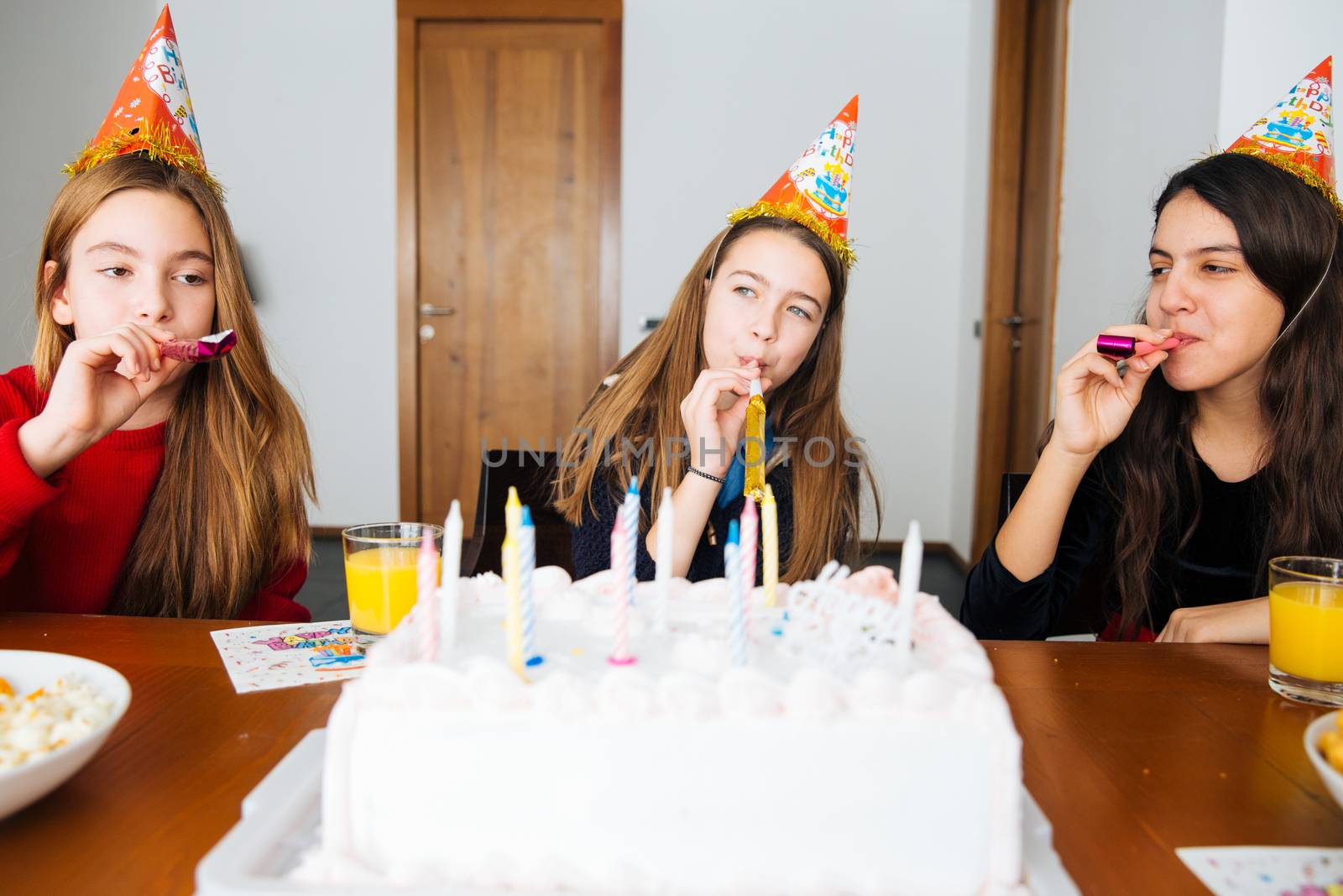 Group of kids celebrate birthday together and blowing in the whistles