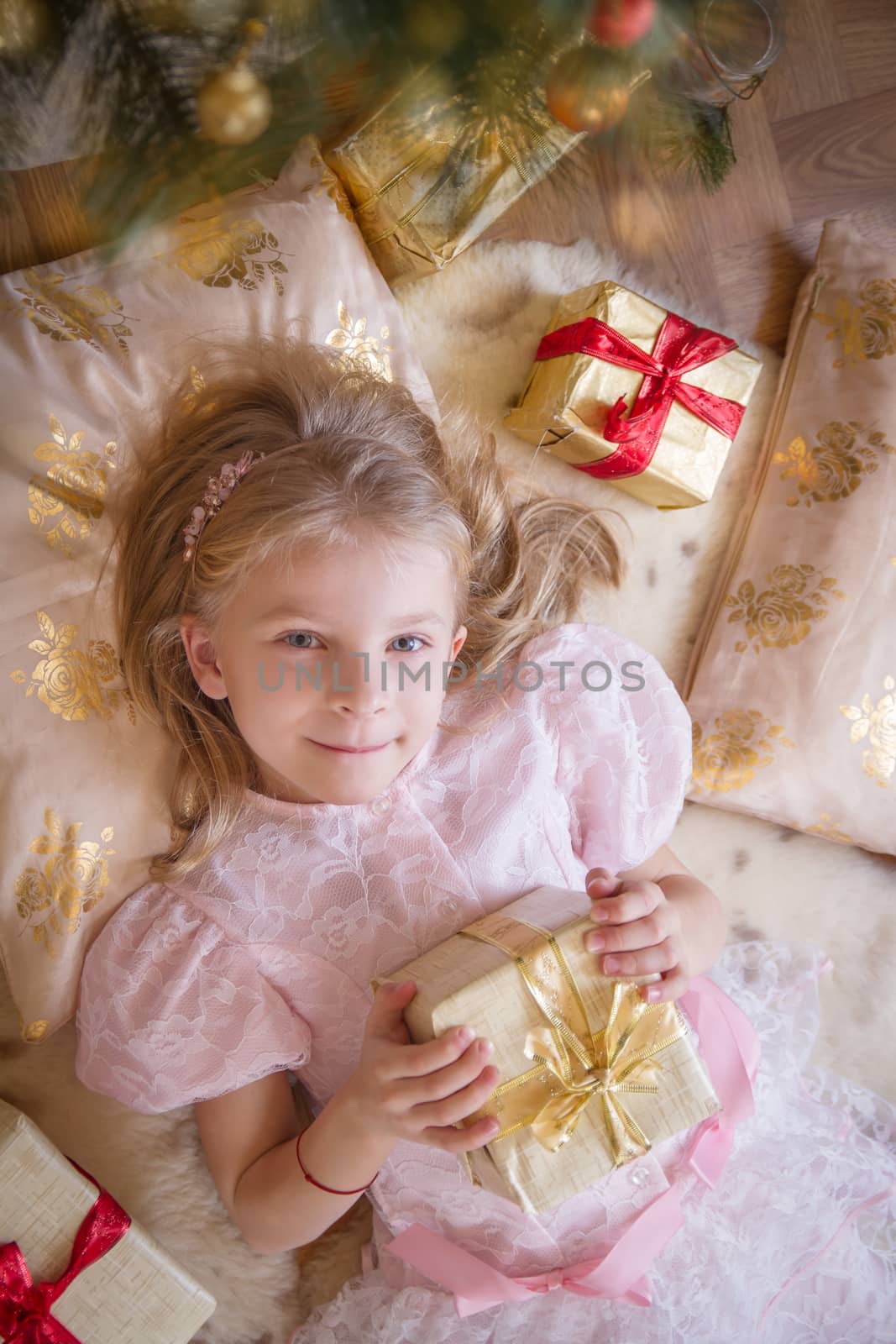 Top view of smiling female kid with golden present by Angel_a