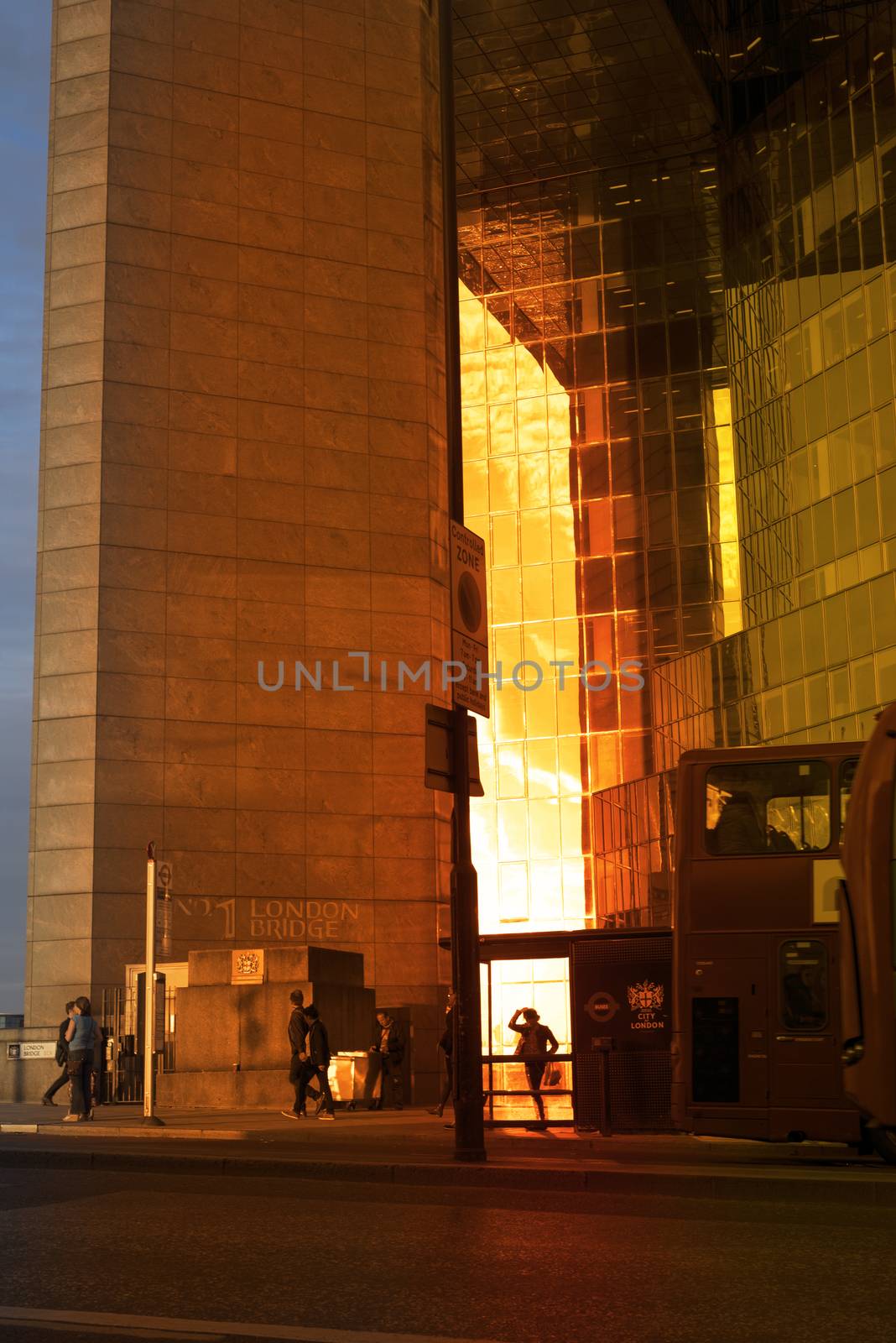 sunset silhouette of a woman at bus stop.tif by morrbyte