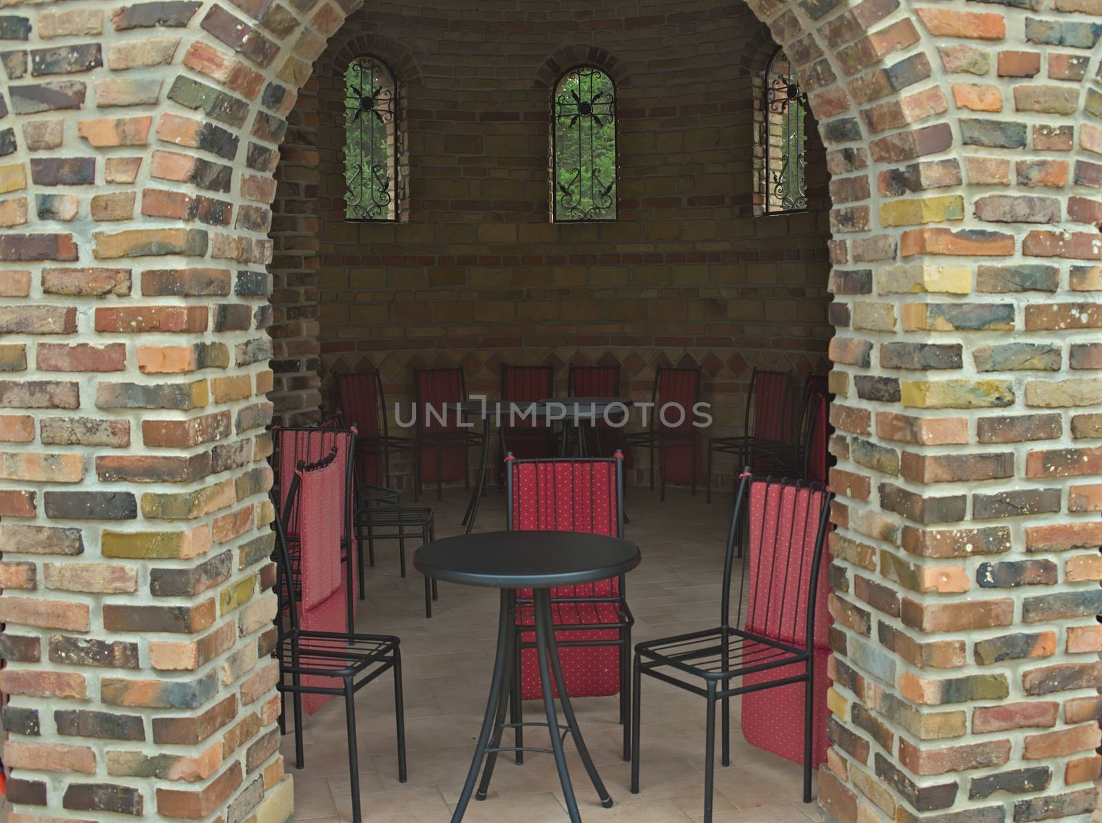 Bricks entrance into empty cafe with chairs and tables by sheriffkule