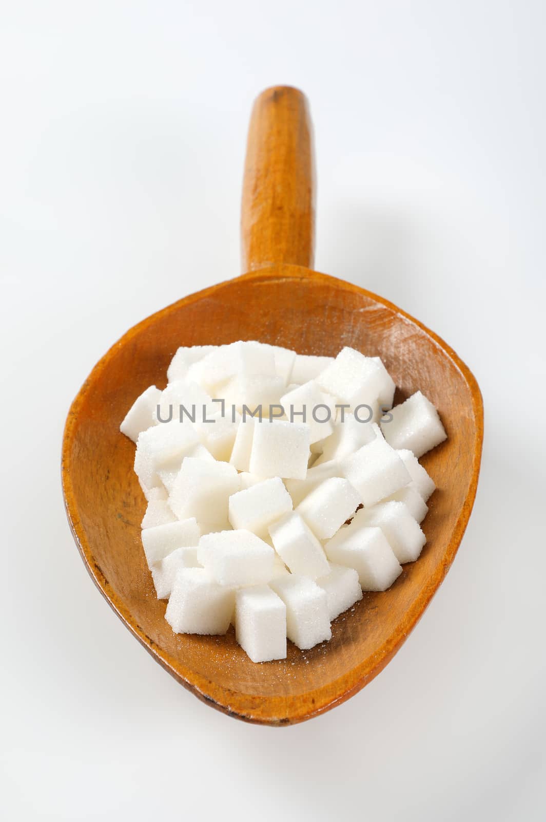 scoop of white sugar cubes on white background