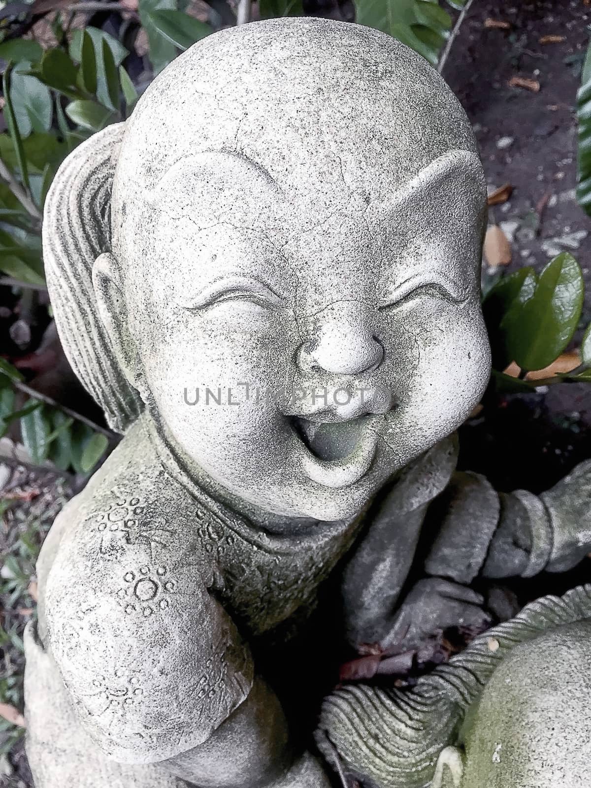 Statue of an old smiling boy