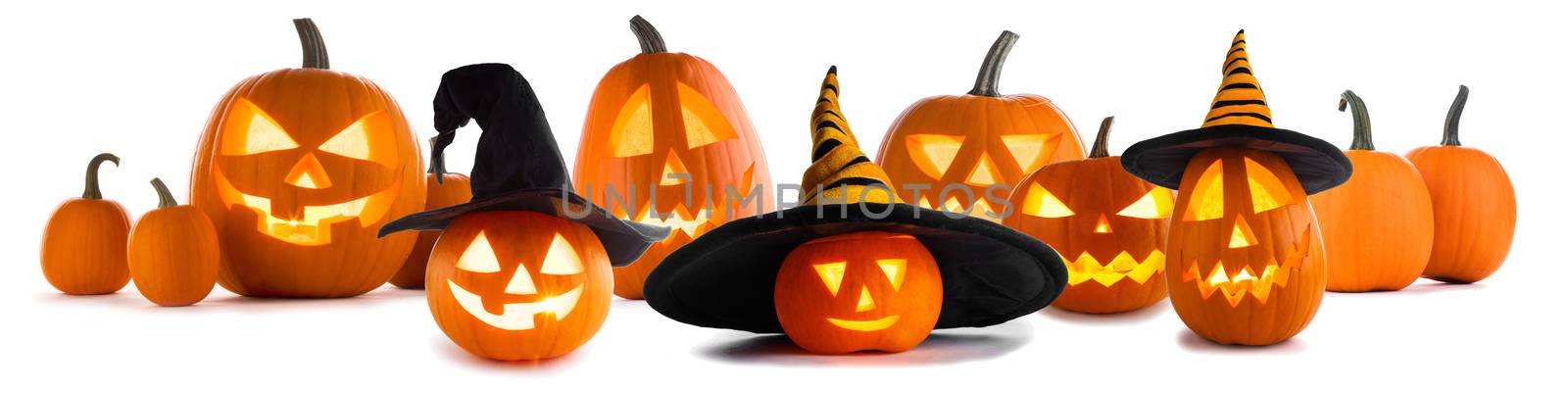 A collection of Jack O Lantern Halloween pumpkins with various different designs and witches hat in a row isolated on white background