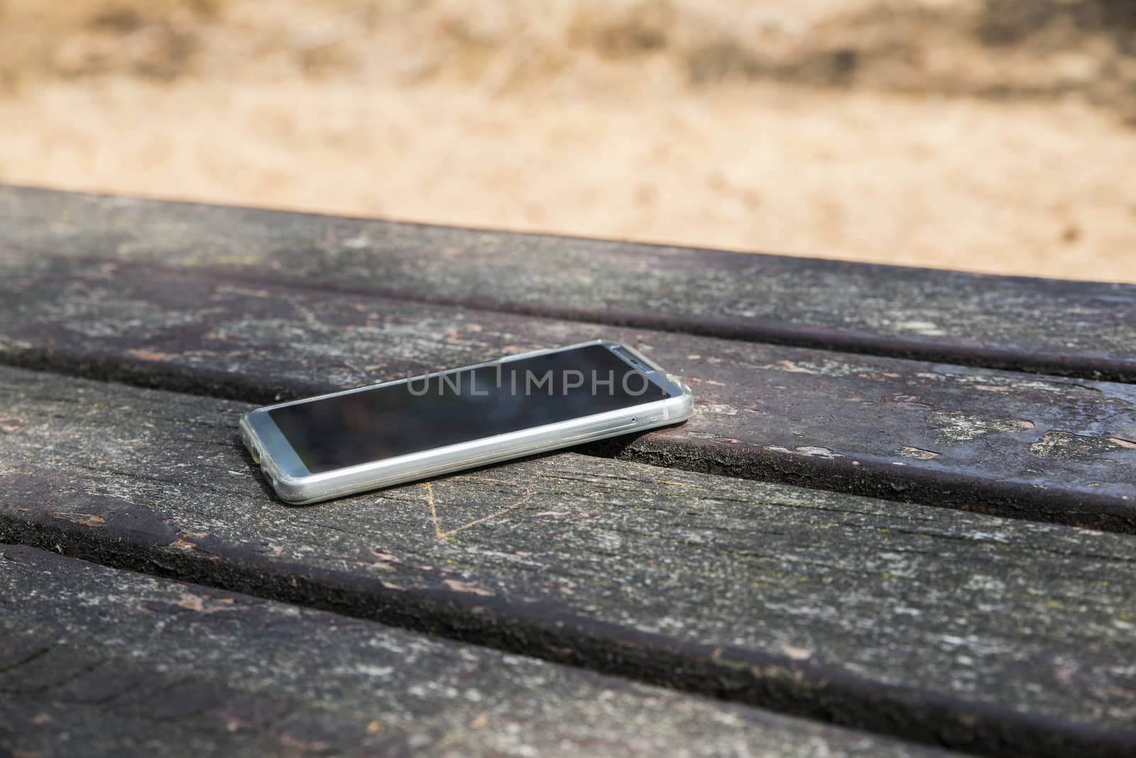 mobile phone lost on a table in the wood