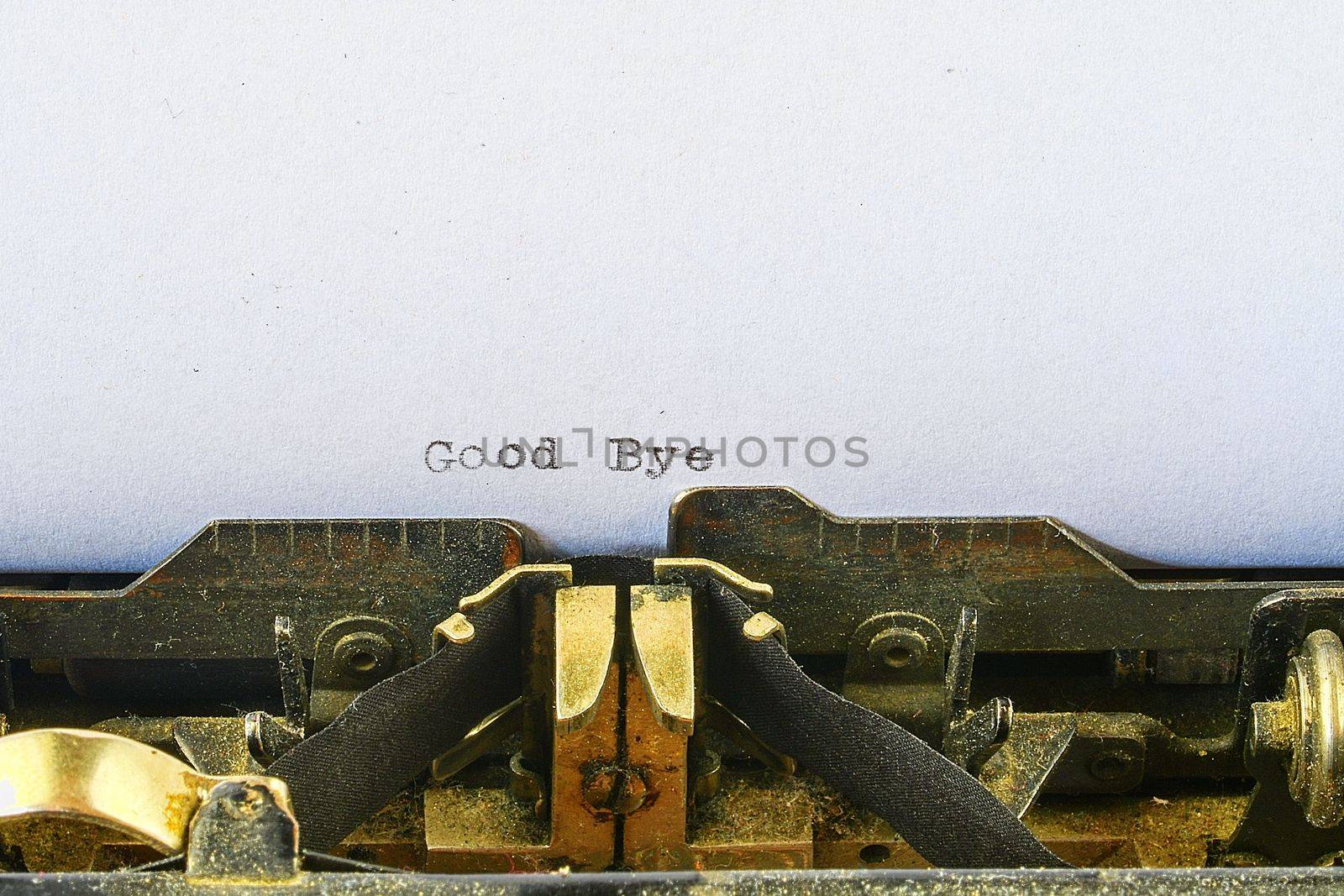 Closeup on vintage typewriter. Front focus on letters making Good Bye text. concept image with retro office tool.