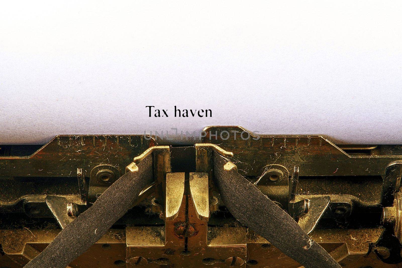 Closeup on vintage typewriter. Front focus on letters making TAX HAVEN text. Business concept image with retro office tool.