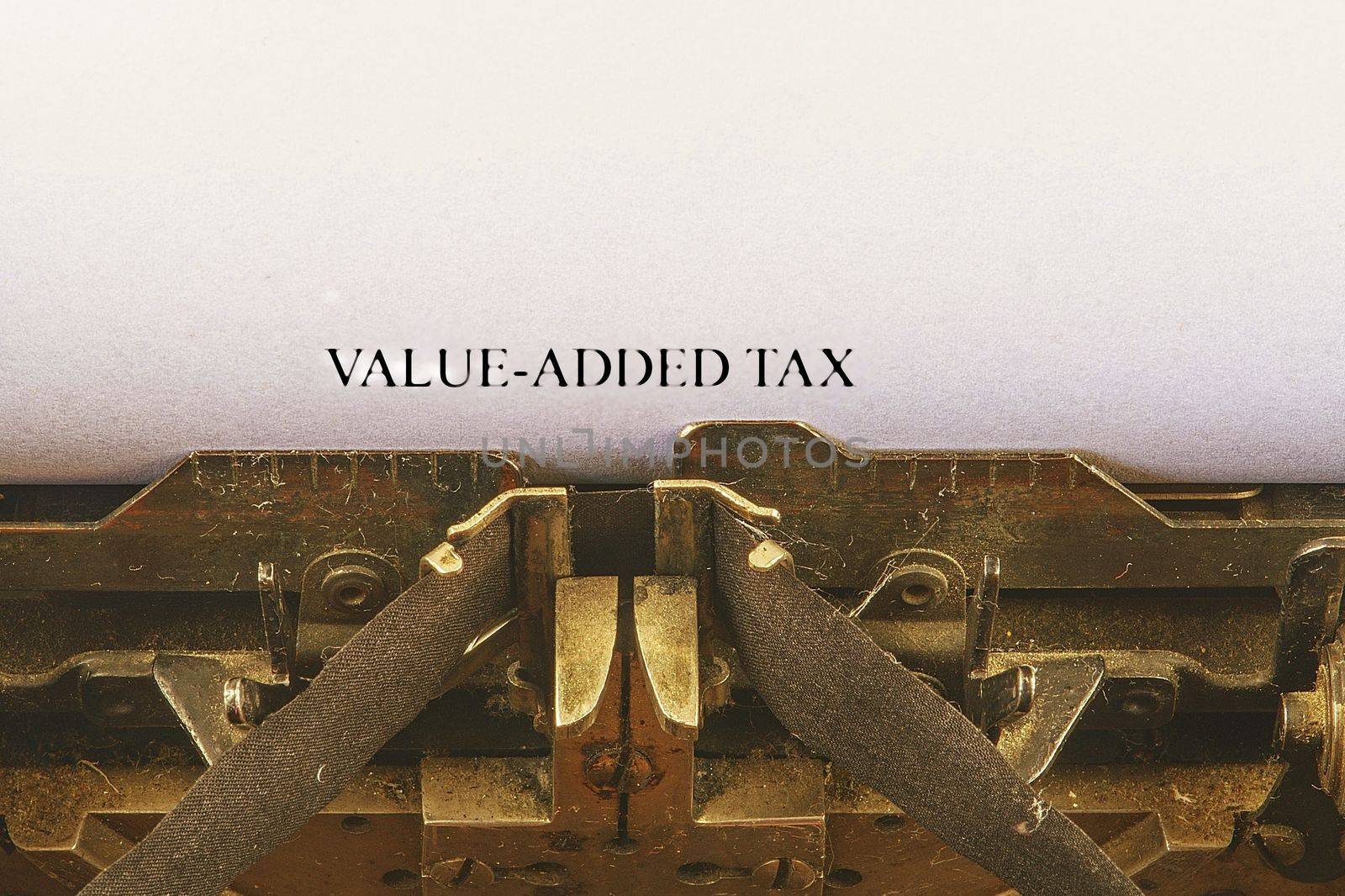 Closeup on vintage typewriter. Front focus on letters making VALUE-ADDED TAX text. Business concept image with retro office tool.