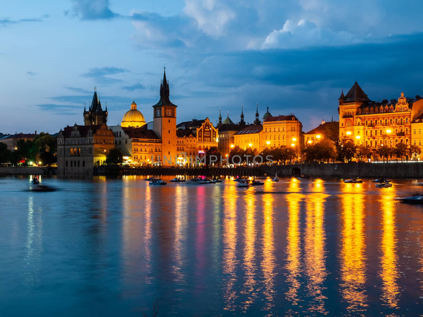 Historical buildings of Smetana Embankment reflected in the water of Vltava River on summer evening. Prague, Czech Republic by pyty