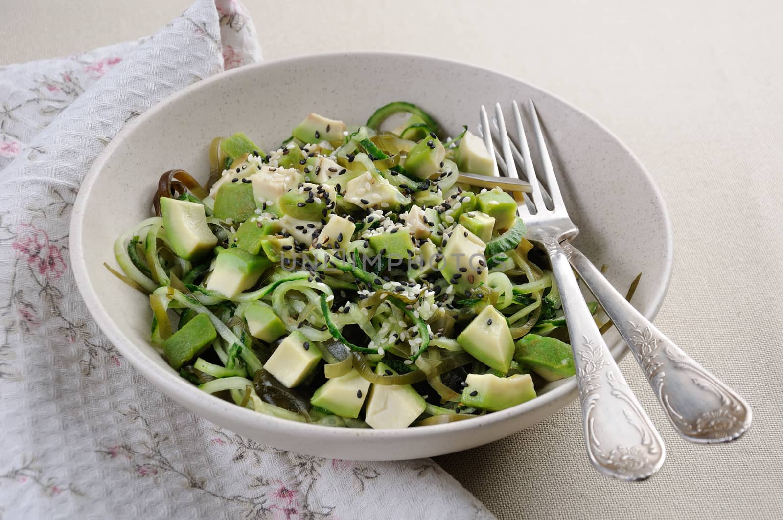 Salad from noodles from cucumbers and laminaria, slices of avocado with sesame