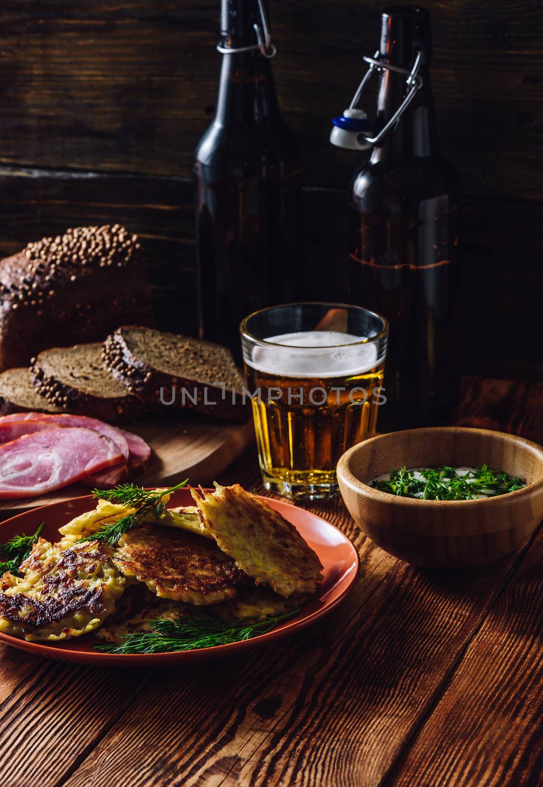 Potato Pancakes with Sour Cream, Greens, Smoked Meat and Glass of Beer. Vertical Orientation.