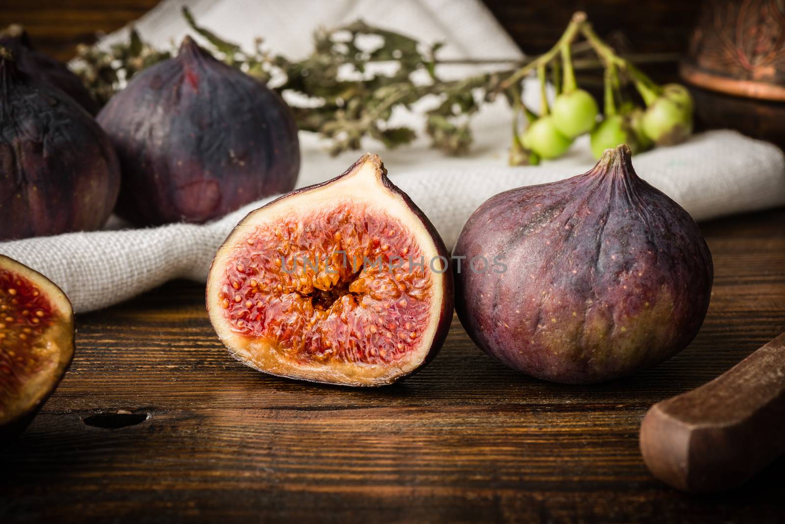 Ripe seasonal figs on wooden table with sliced one by Seva_blsv