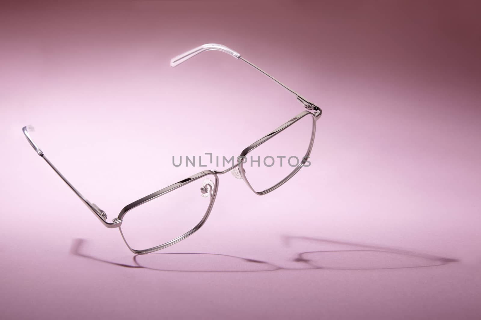 Studio shot of silver glasses at pink background.