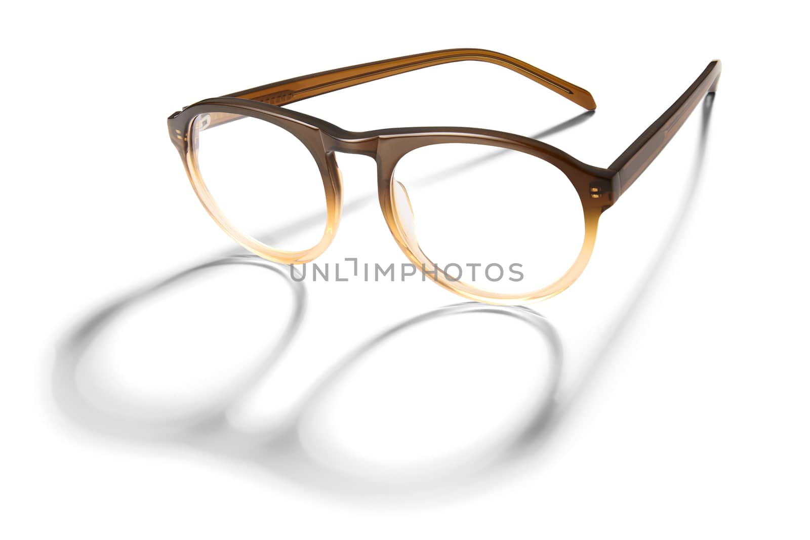 Advertising photo of brown glasses with long shadow isolated on white background.