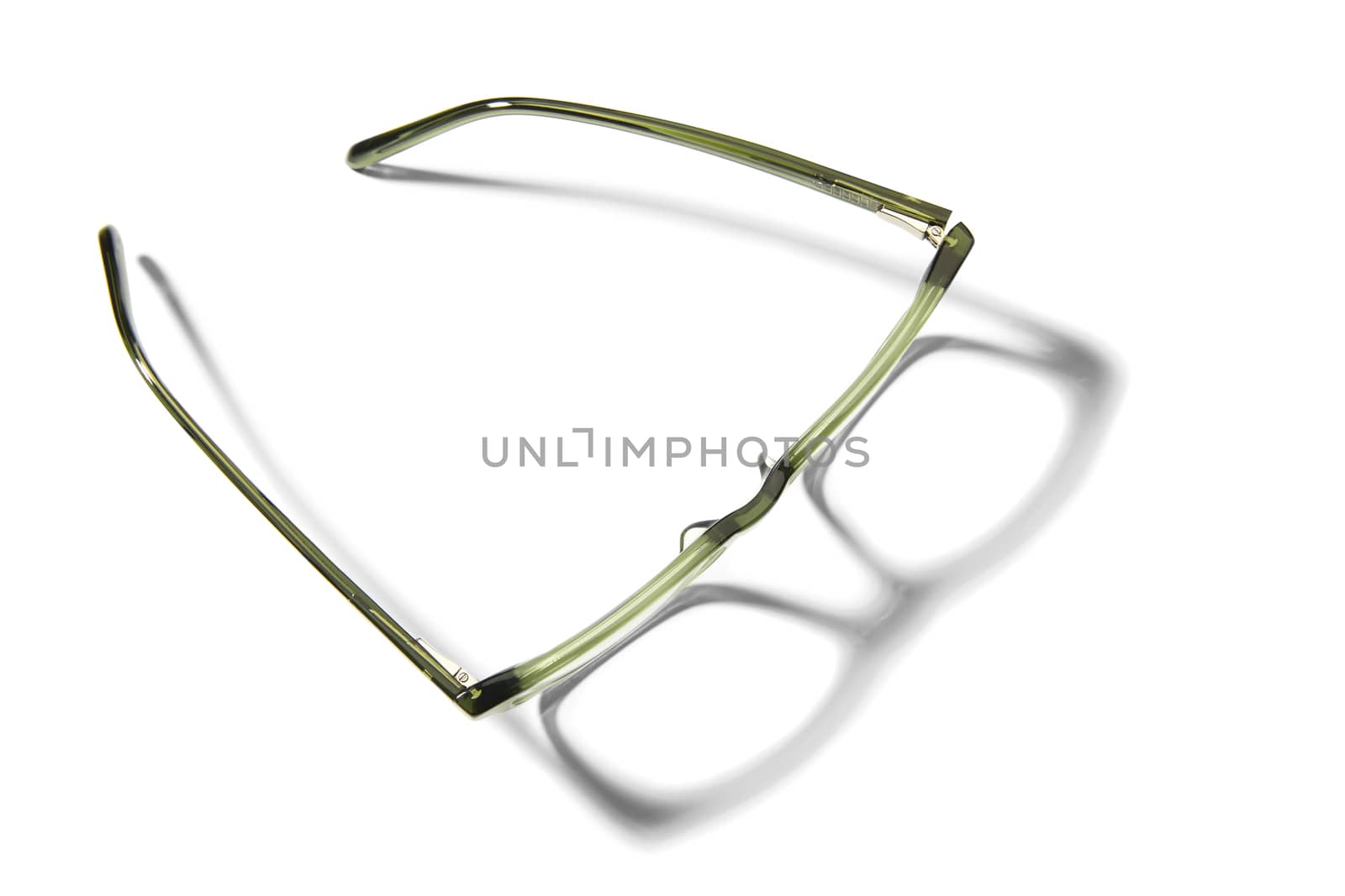 Studio shot of pair of green eyeglasses on white background with shadow.