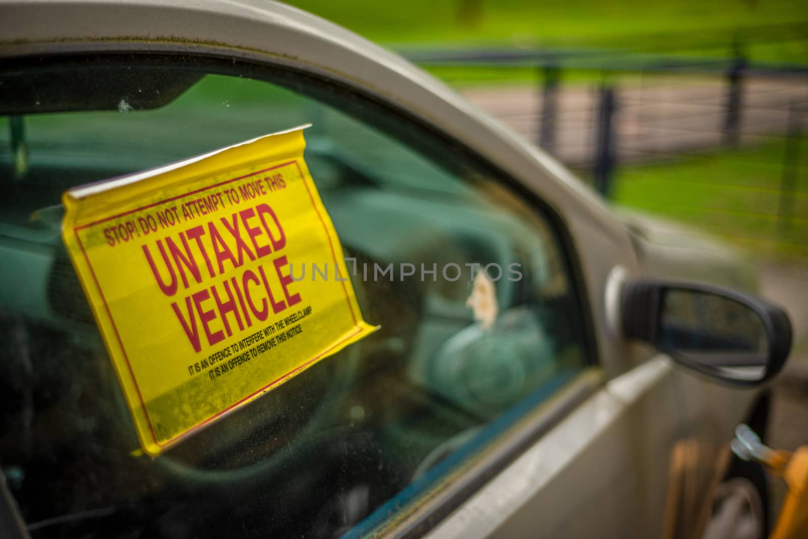 Detail Of A Warning Sign On The Window Of An Untaxed Vehicle With A Clamp On The Front Wheel