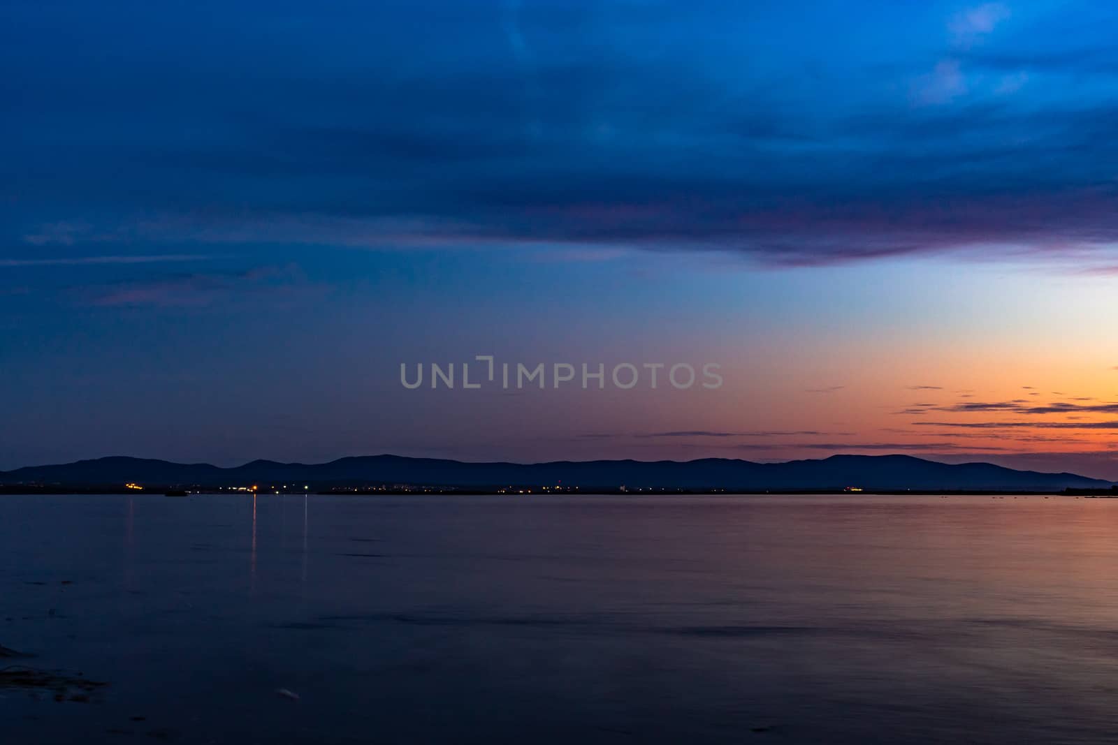 The sun went over the horizon of the Amur river in the city of Khabarovsk, forming magnificent colors in the sky. Beautiful colors in the sky, which are reflected in the water.