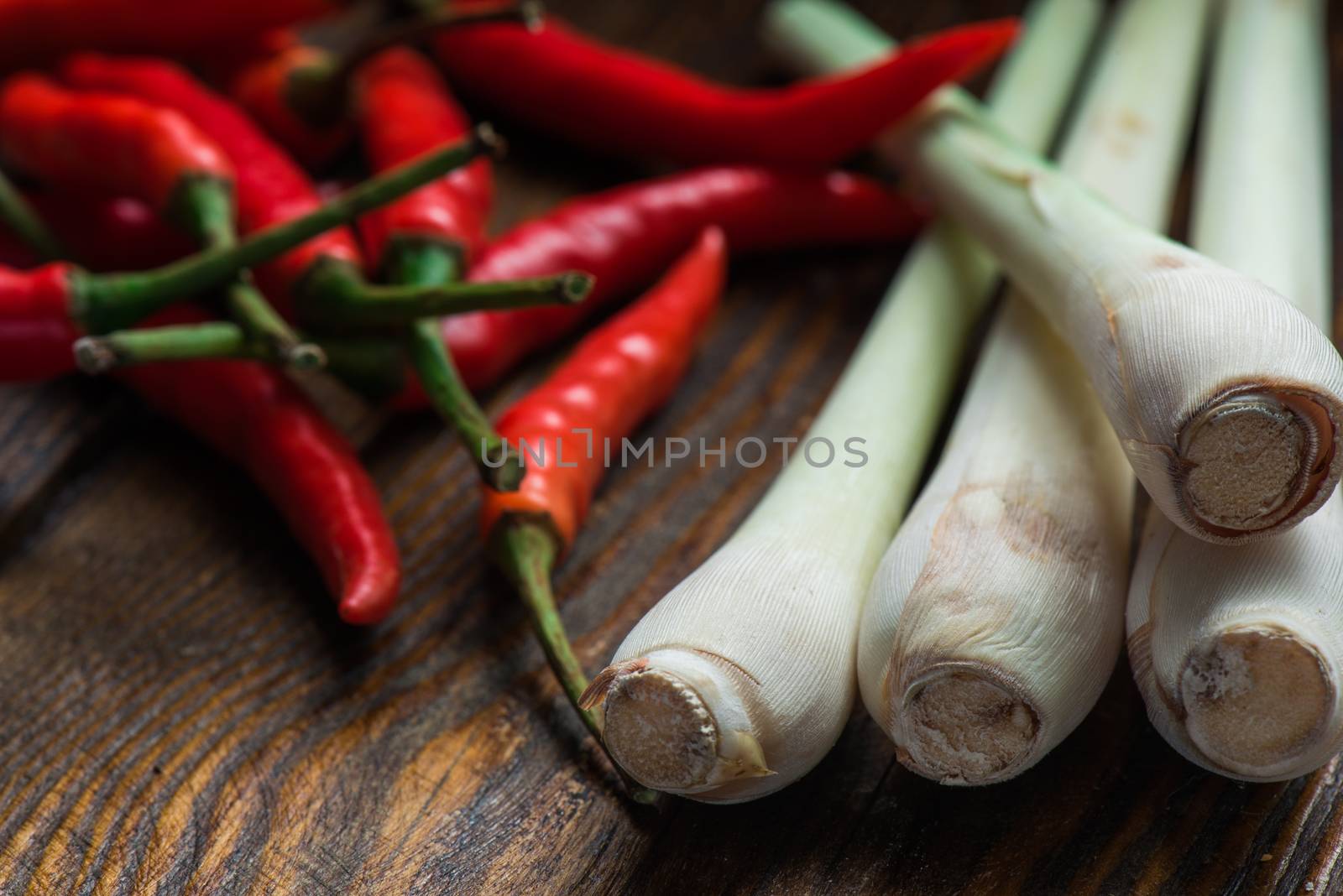Mexican hot chili peppers with lemongrass scattered on the wooden table by Seva_blsv