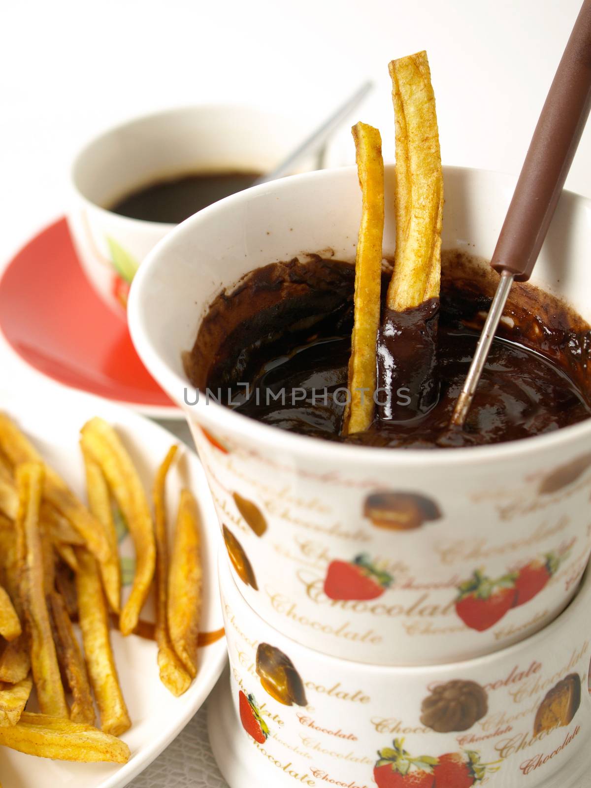 Homemade potatoes chips with chocolate fondue on white background