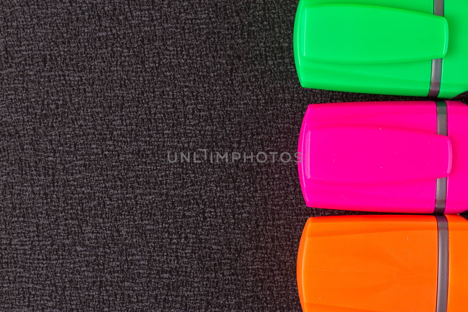 the Colored markers on a black background