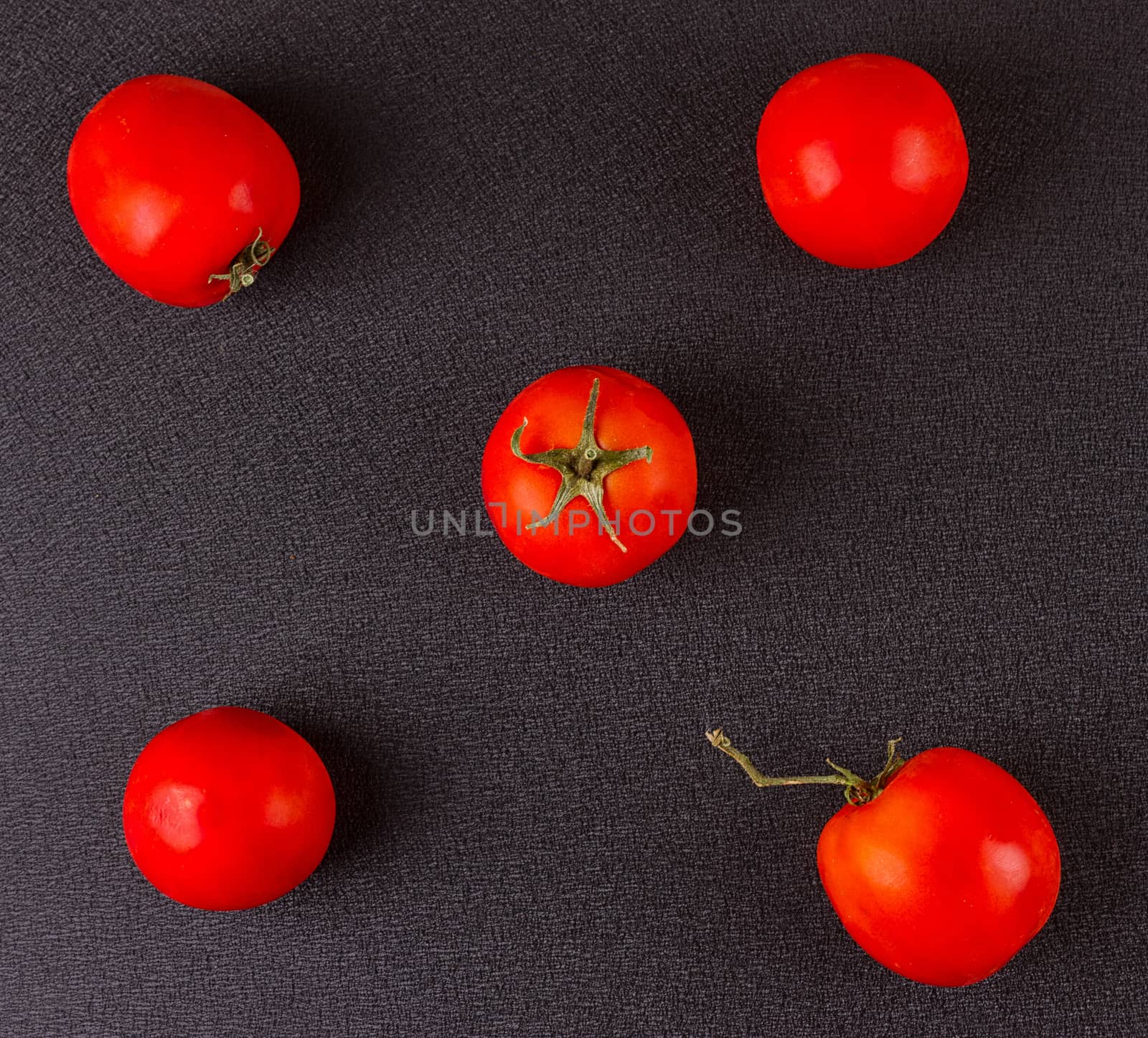red tomatoes on black background. top view