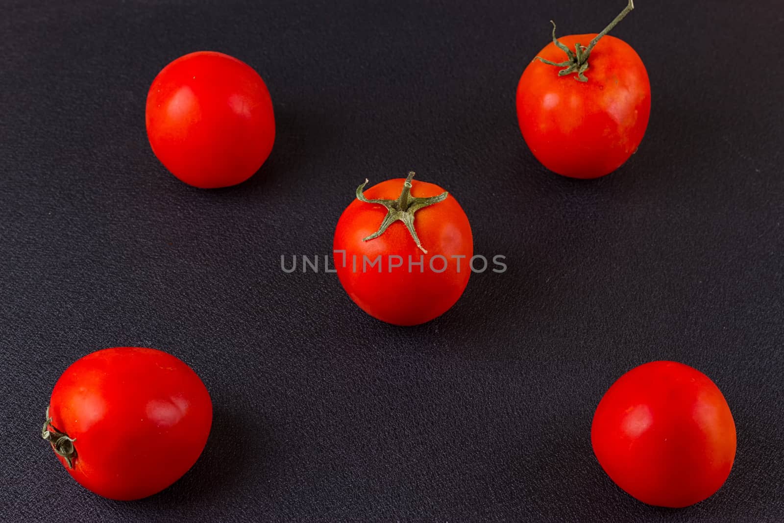 red tomatoes on black background. top view