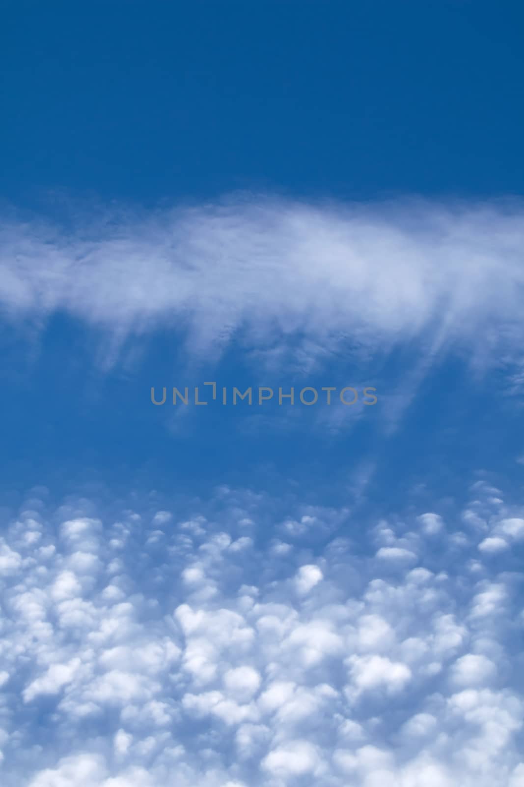 Streaky and puffy Cirrocumulus Clouds against blue sky. Portrait orientation.