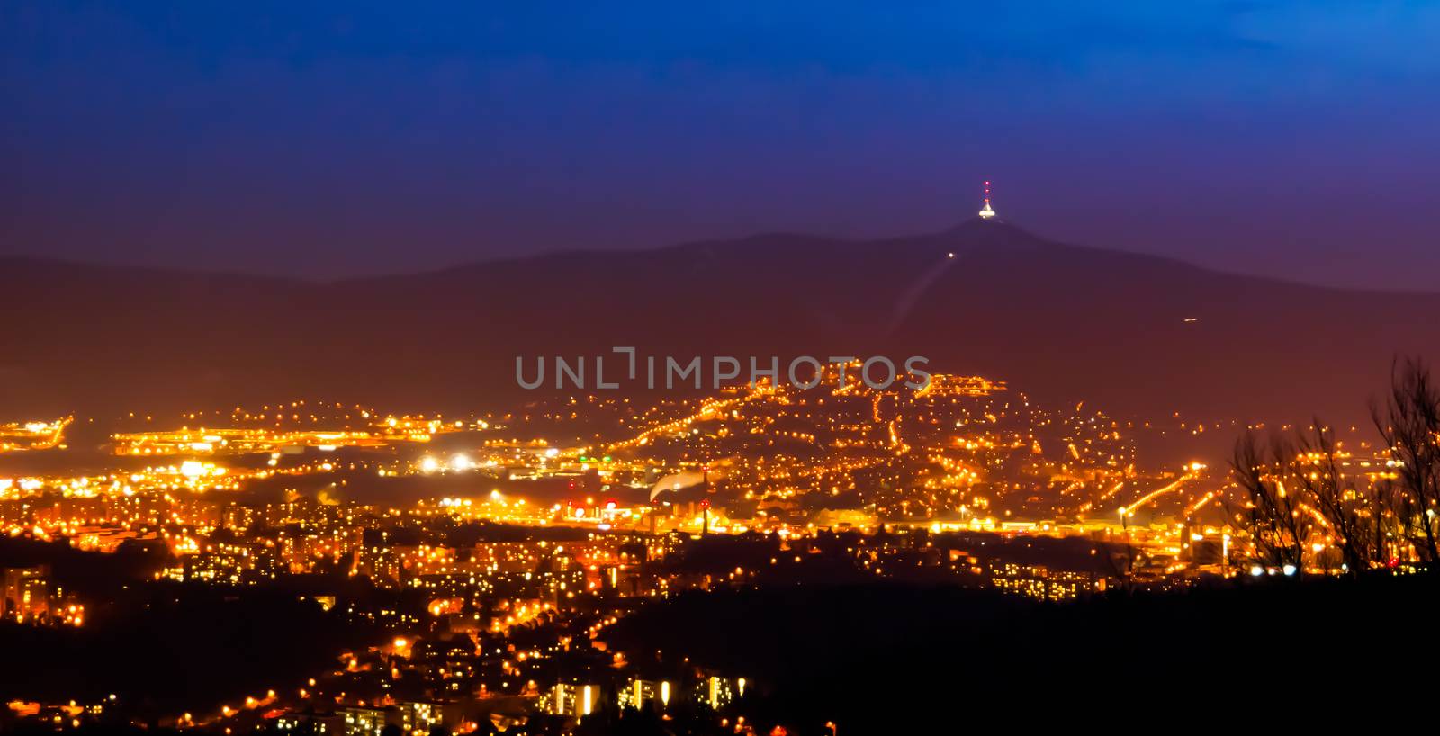 Evening view of illuminated Liberec city and Jested Mountain. Night scene by pyty