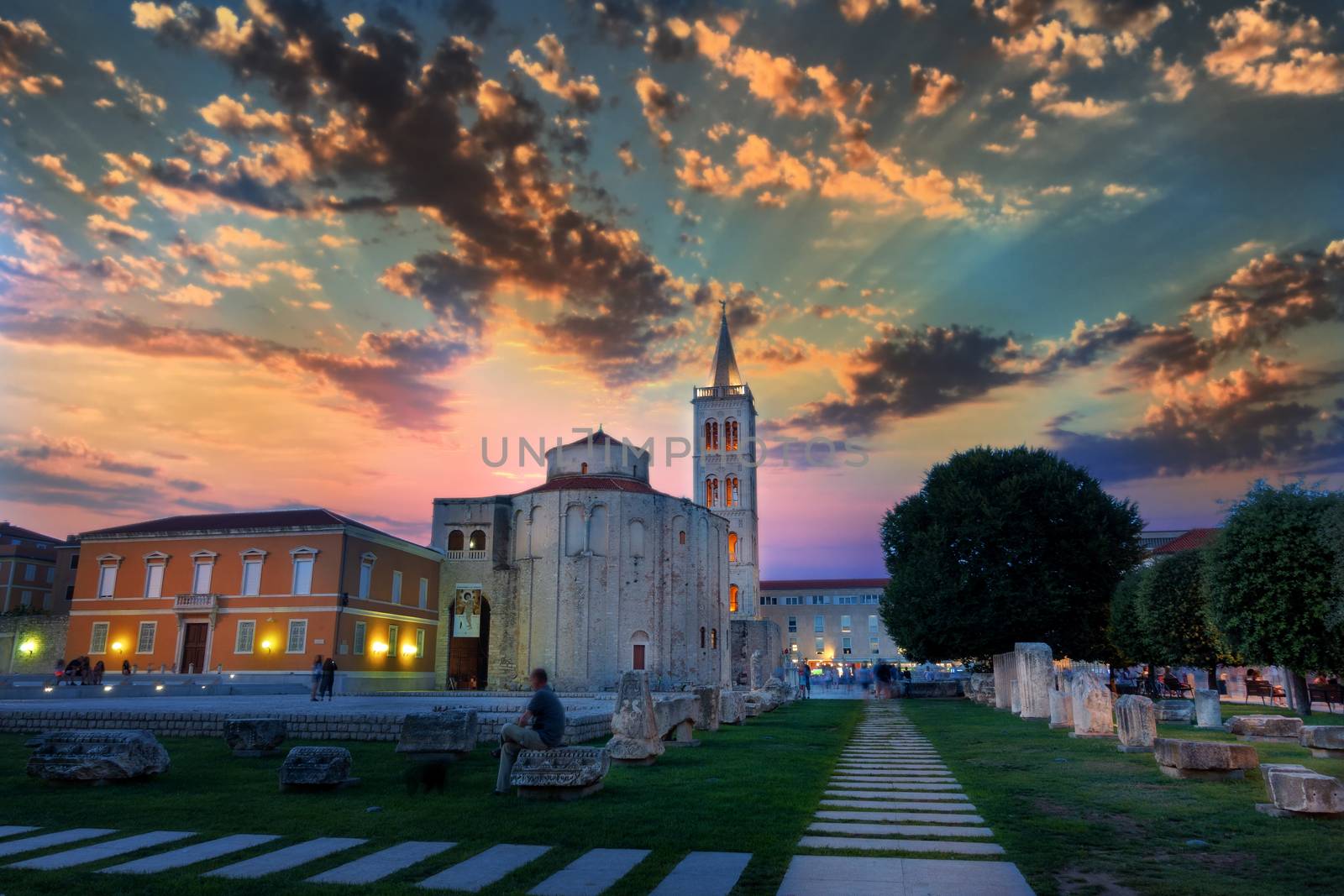 Dramatic sky in Sunset above the old roman square in Zadar, Croatia, with the ancient church of St Donat, long exposure, people blurred and unrecognizable