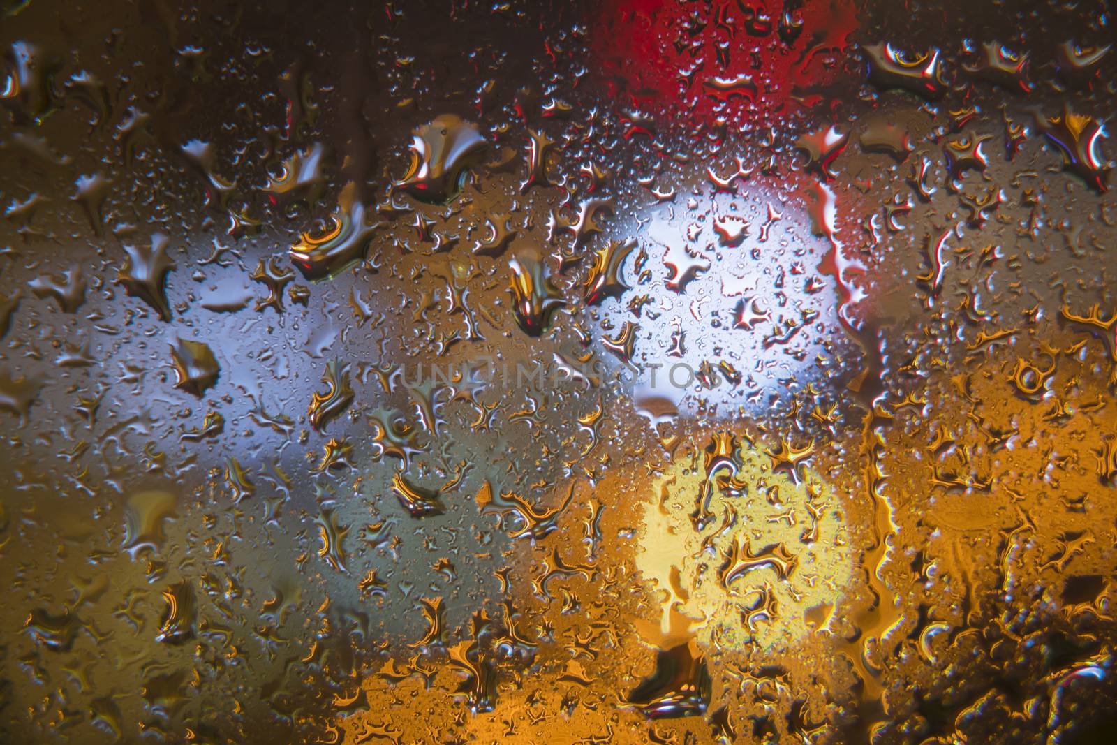 Water drops on window with color background