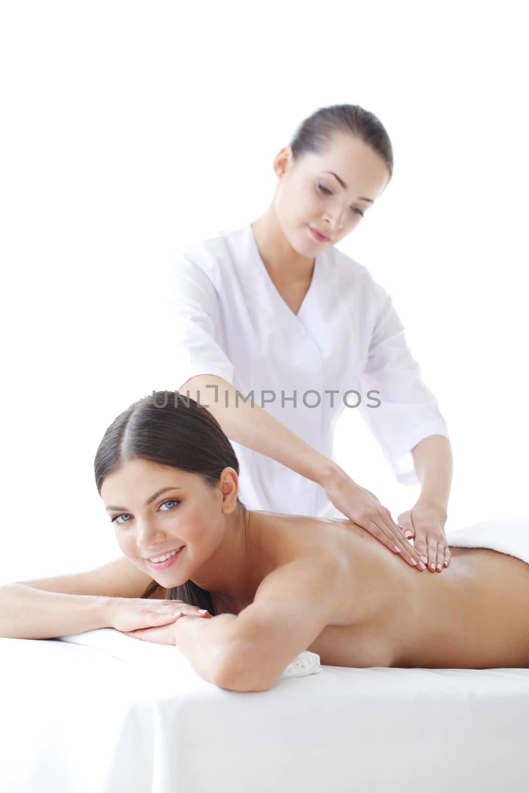 Masseur makes massage for young smiling woman isolated on white background
