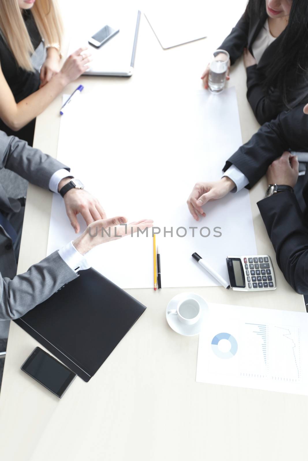 Business people brainstorming at office desk, they are analyzing financial reports and pointing out blank paper working with financial data, top view