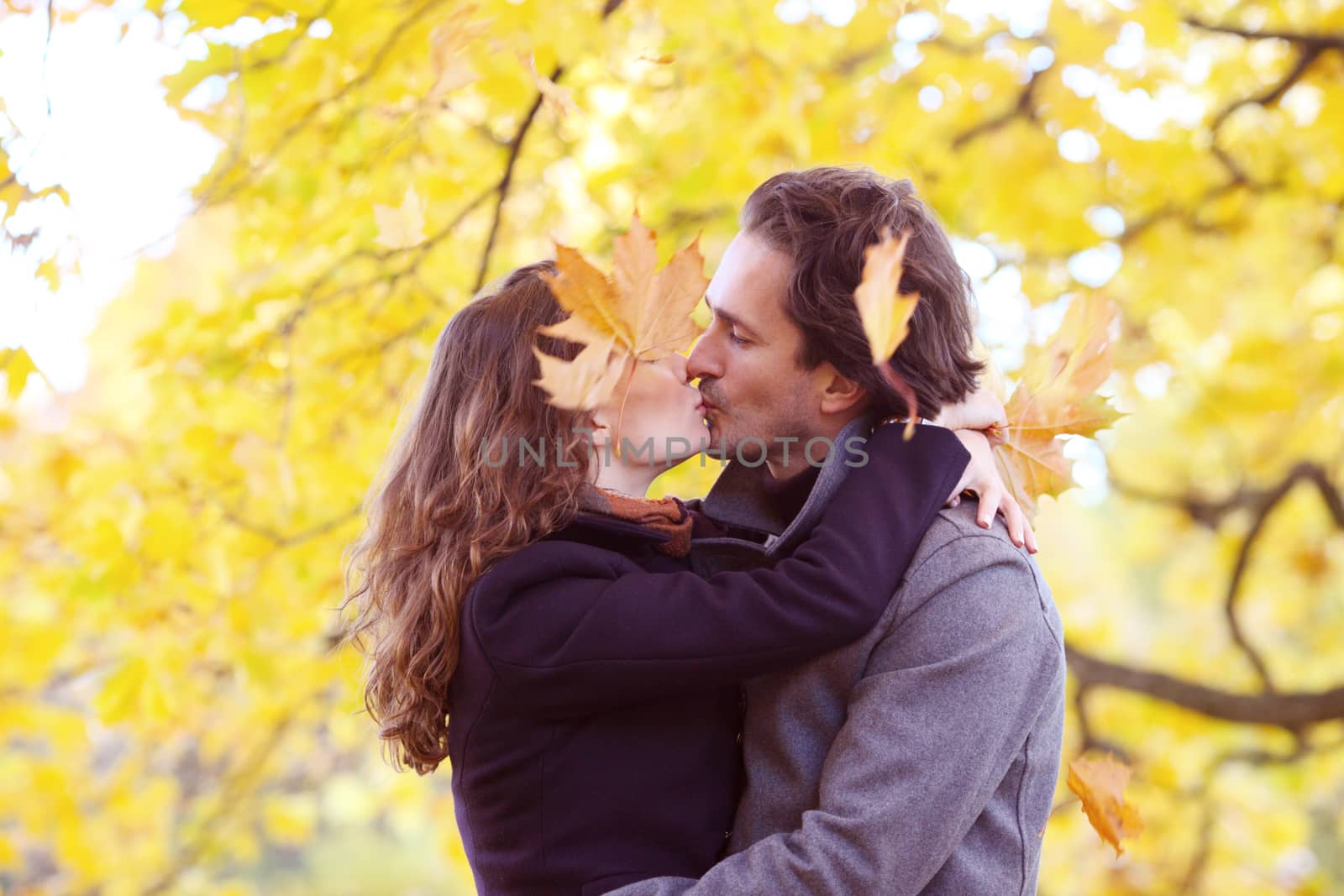 Couple kissing in autumn park, love, relationship, family and people concept