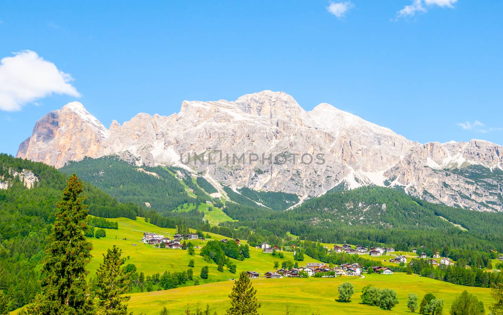 Landscape of Dolomites with green meadows, blue sky, white clouds and rocky mountains by pyty