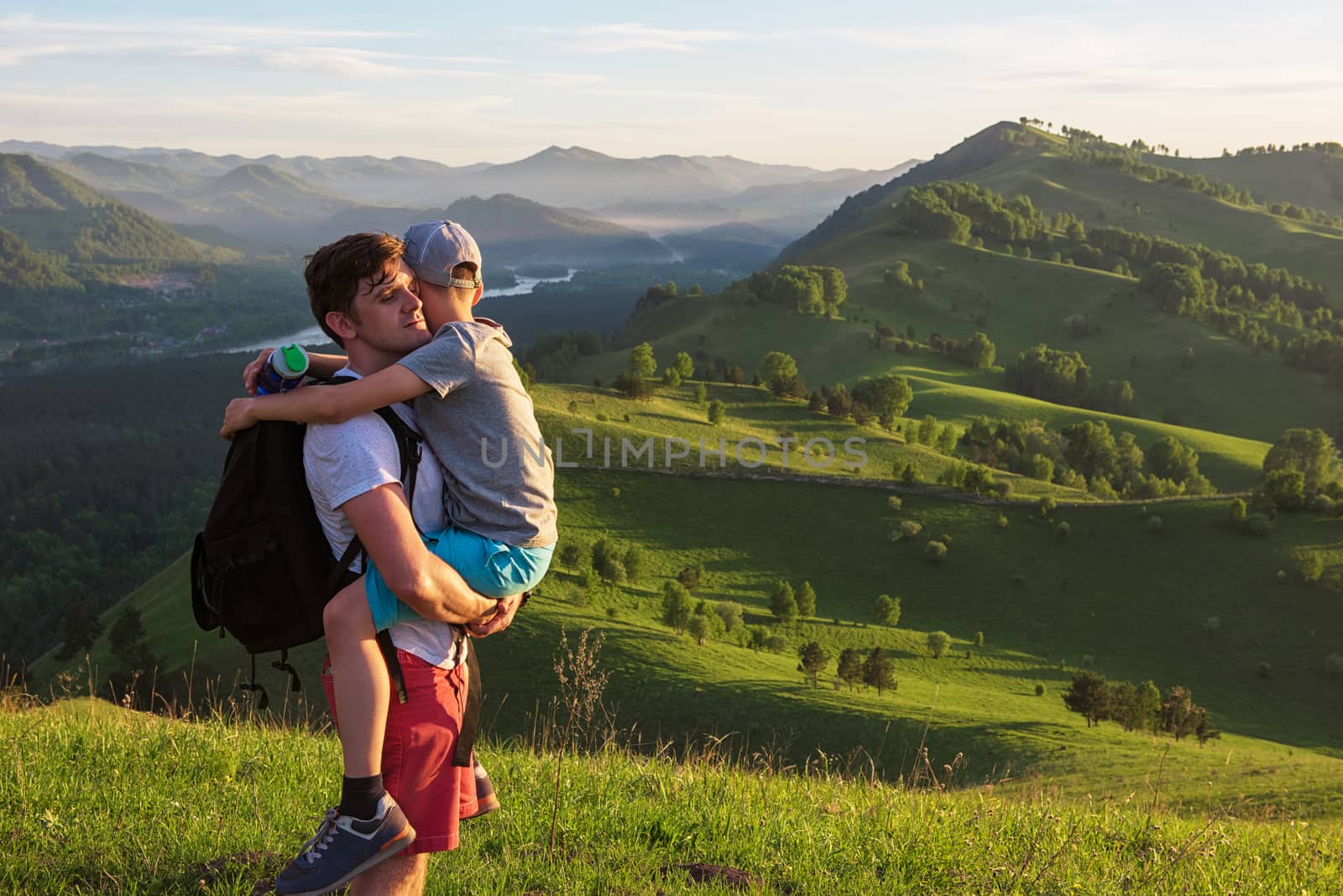 Travel, family and real life concept - happy father and son on the altai mountains background