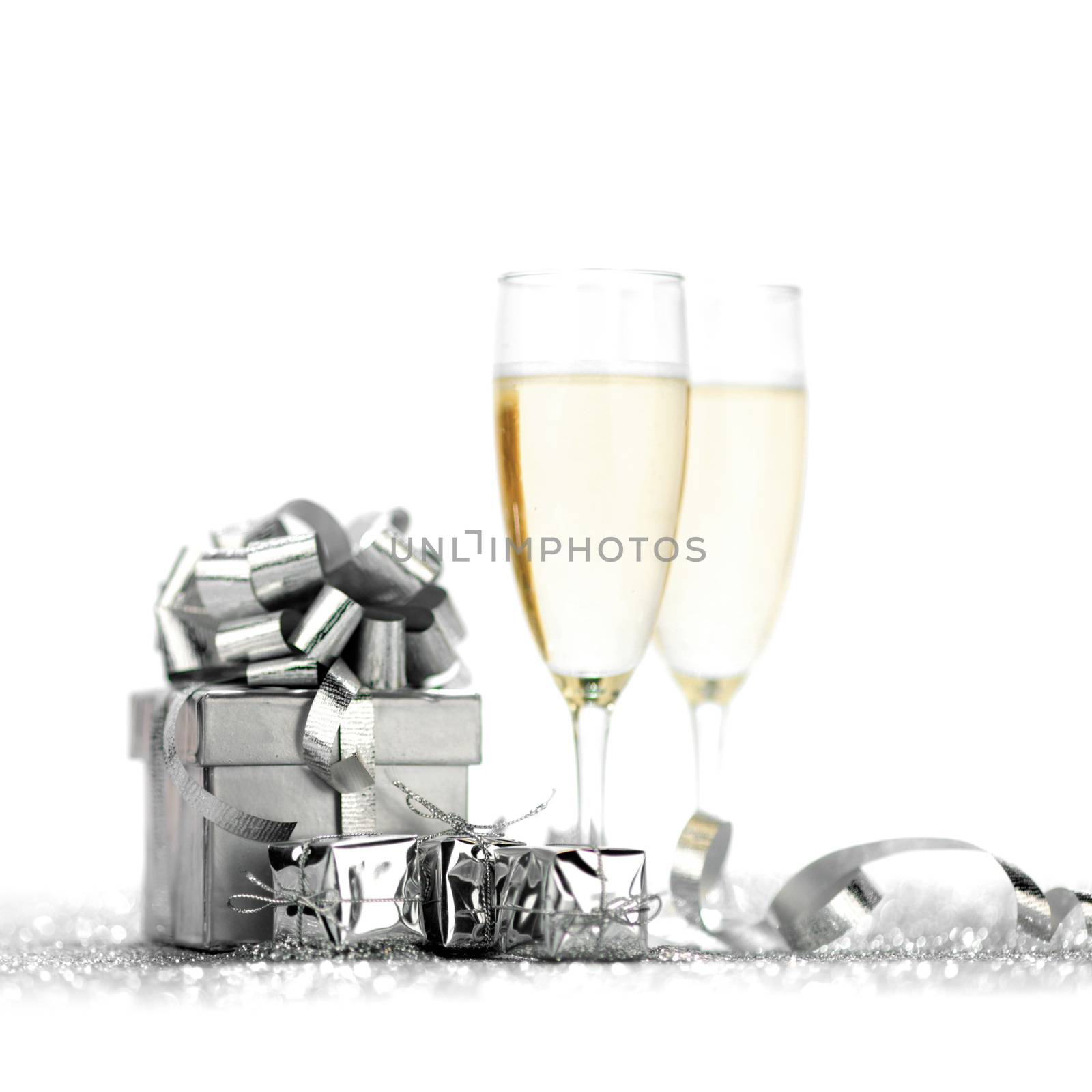 Glasses of champagne and silver gifts isolated on white