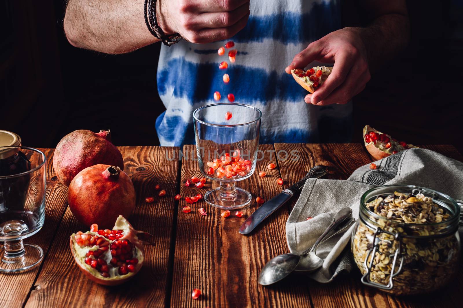 Man Puts Pomegranate Seeds into the Glass. by Seva_blsv