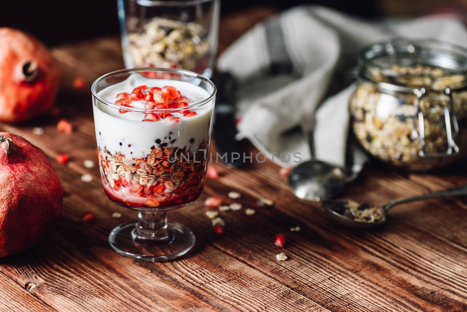 Pomegranate Parfait with Ingredients on Backdrop. Series on Prepare Healthy Dessert with Pomegranate, Granola, Cream and Jam.