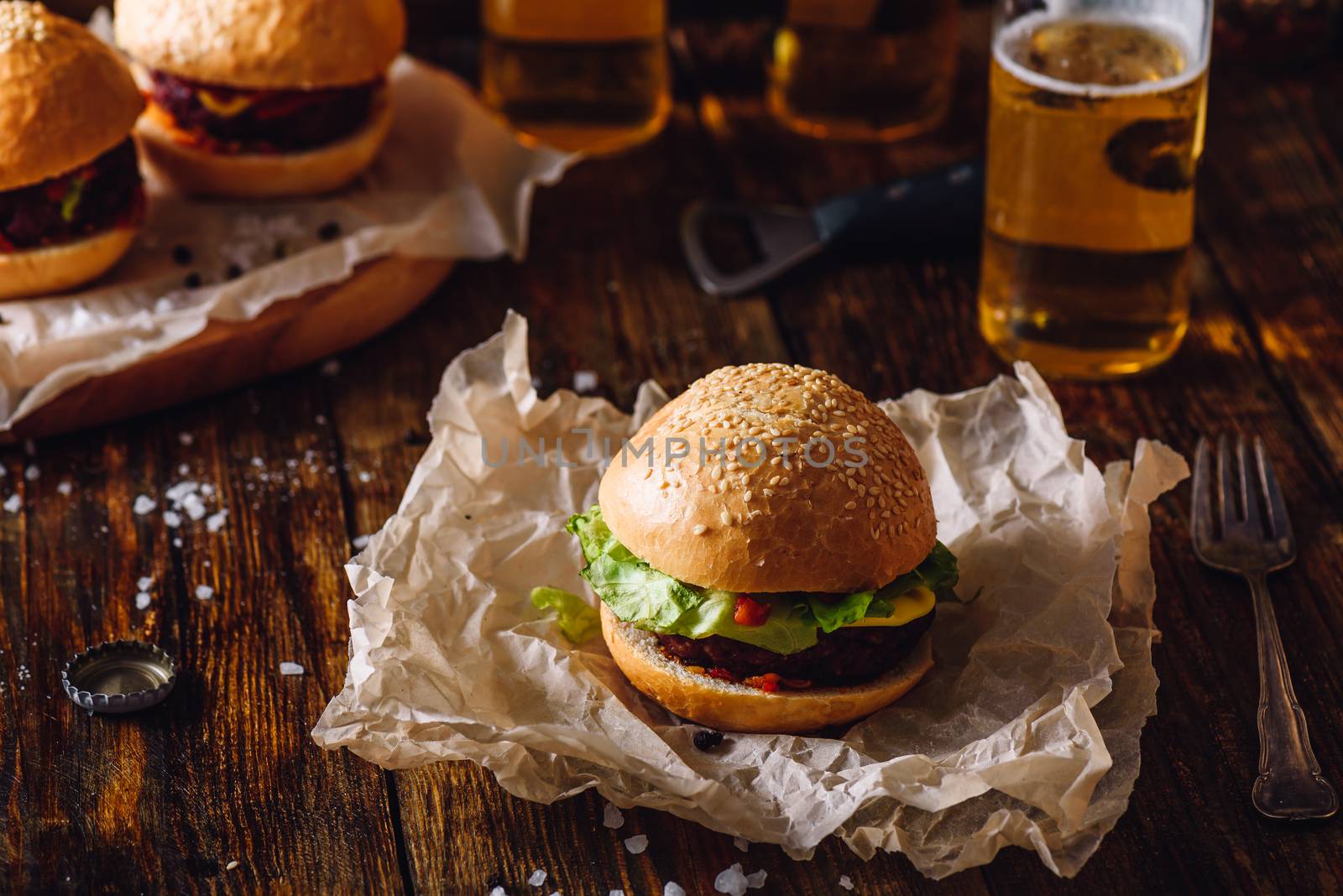Homemade Burger on Paper with Beer Bottle.