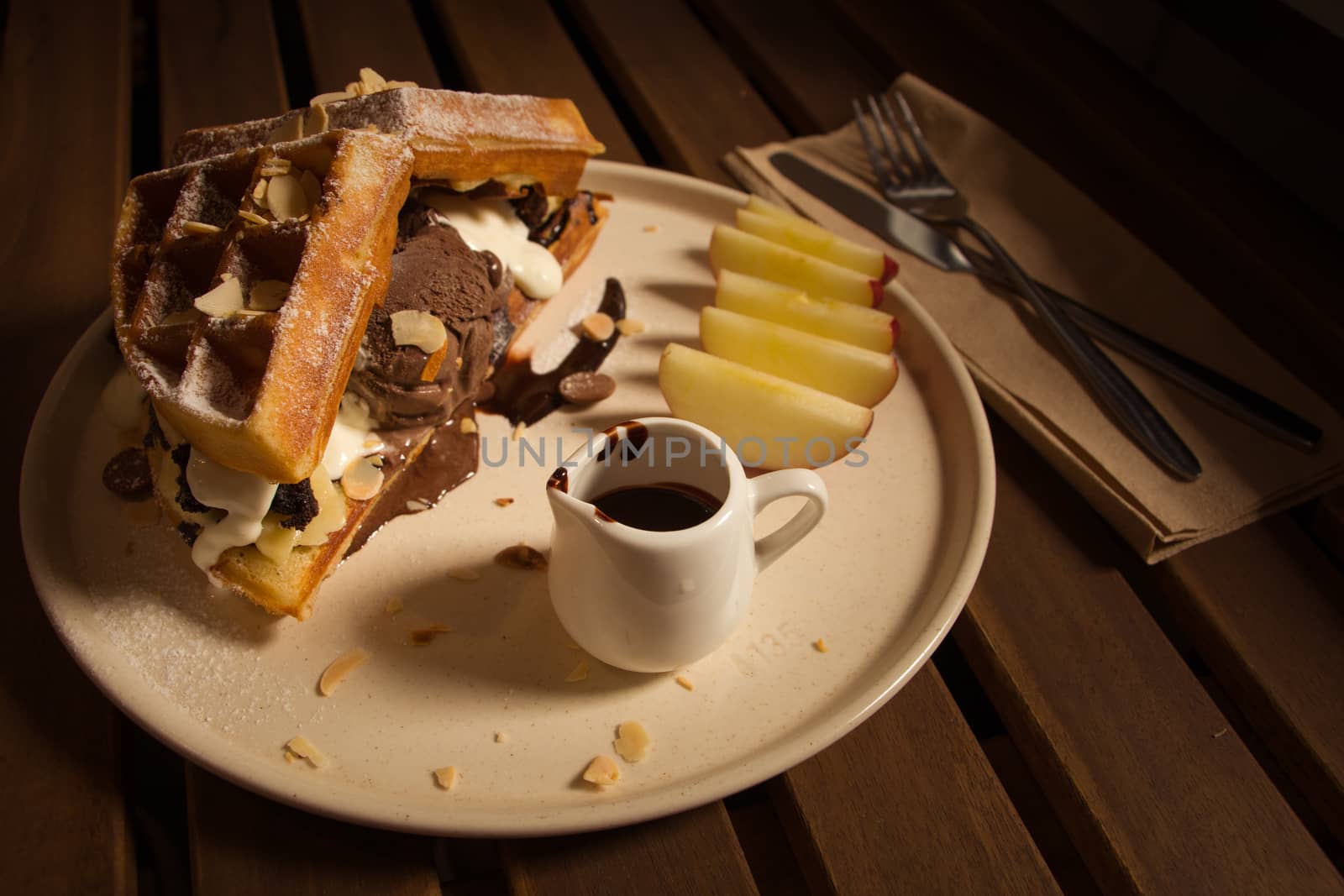 Waffle with chocolate sauce and chocolate icecream with brownie and wipcream and apple