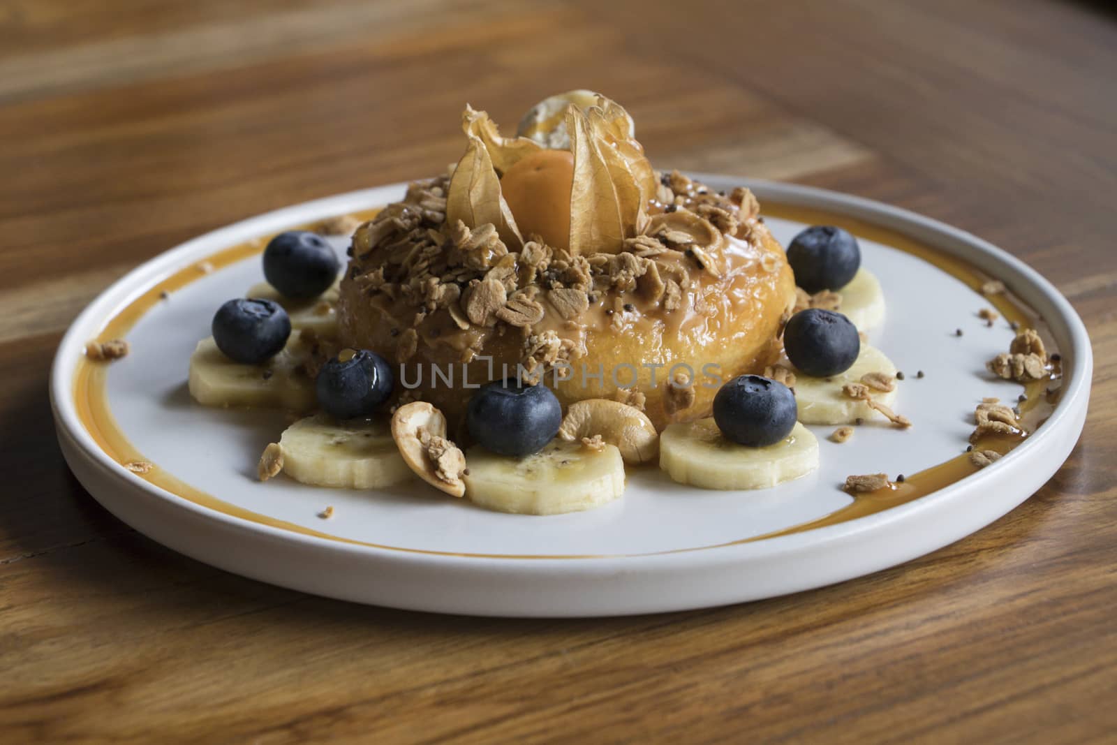 Peanut Butter Cake On top with Granola Banana and Berry on Wooden Table 