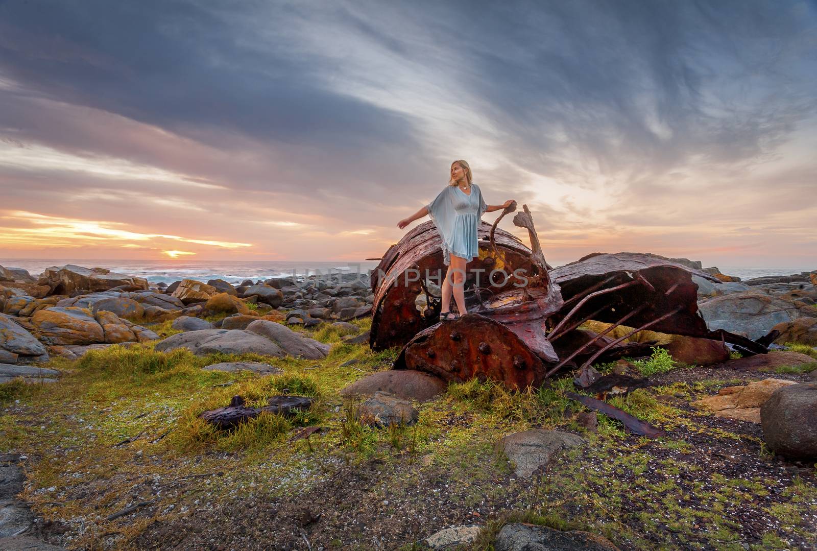 Female explores the rusted remains of a shipwreck parts of which have washed ashore along Australian coastline