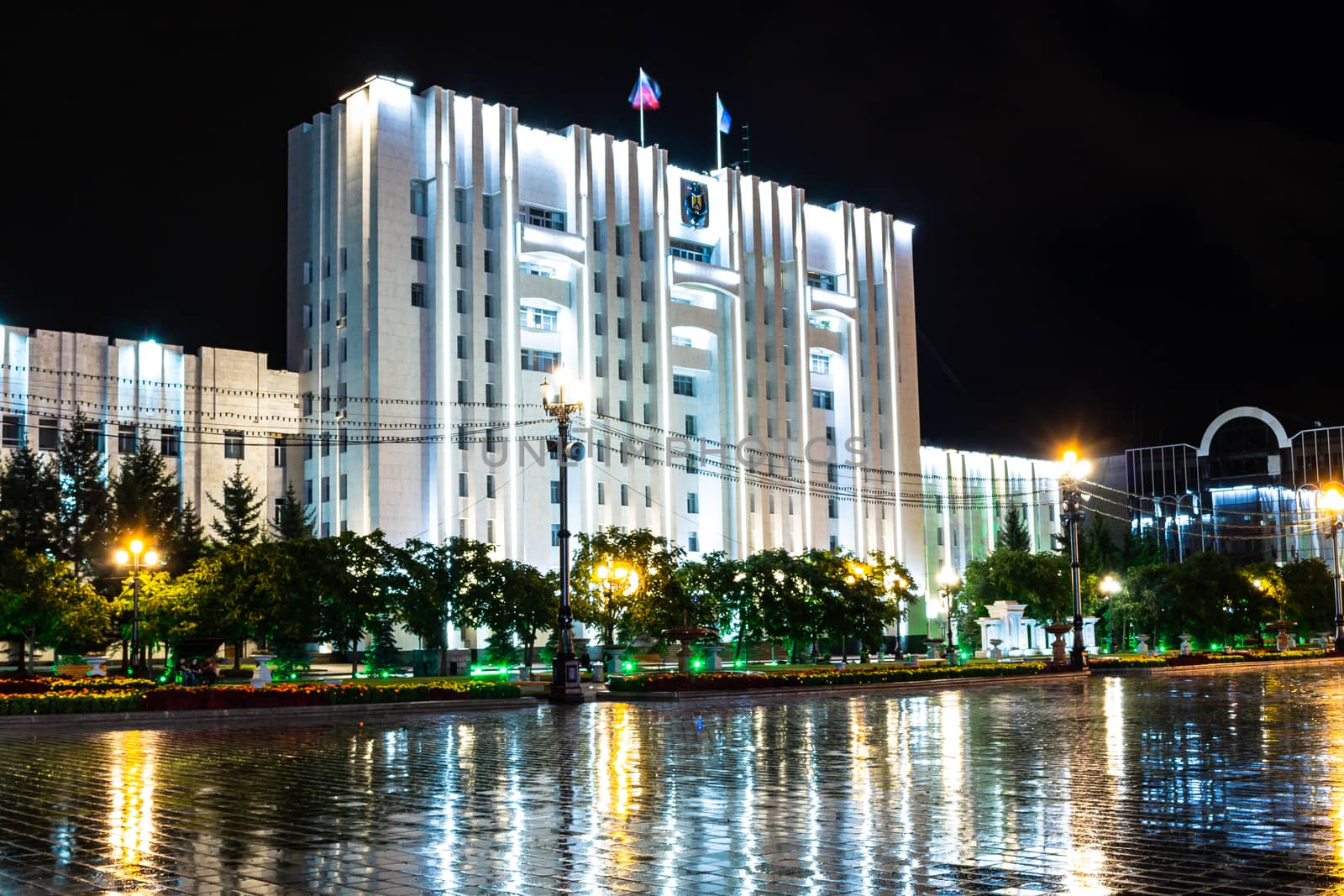 Night city landscape. The main square of the city of Khabarovsk in the light of lanterns, which are reflected in puddles after the rain just passed.