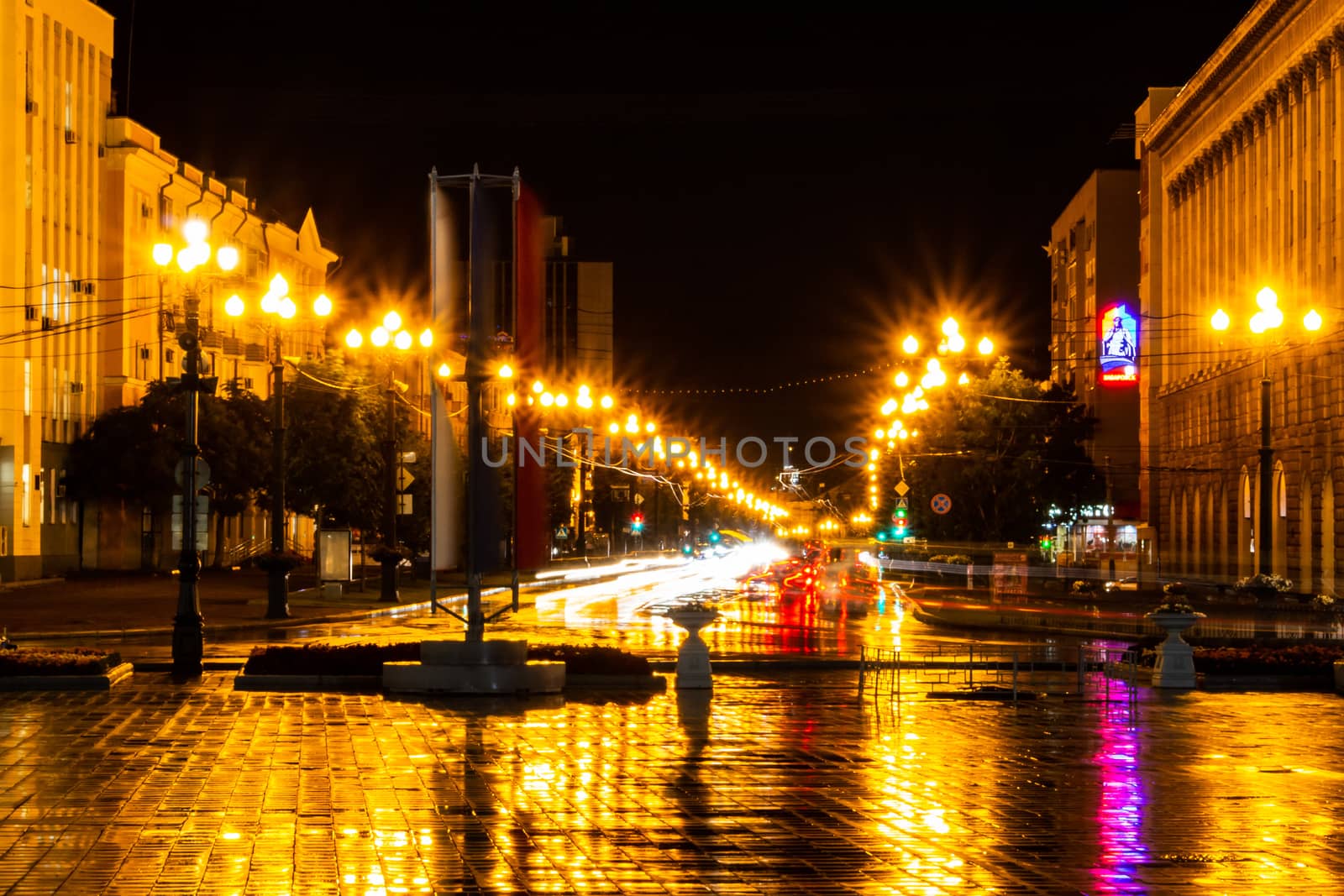 Night city landscape. The main square of the city of Khabarovsk in the light of lanterns, which are reflected in puddles after the rain just passed.