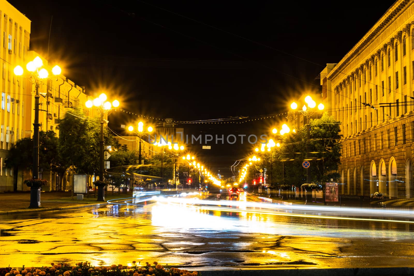 Night city landscape. The main square of the city of Khabarovsk in the light of lanterns, which are reflected in puddles after the rain just passed.