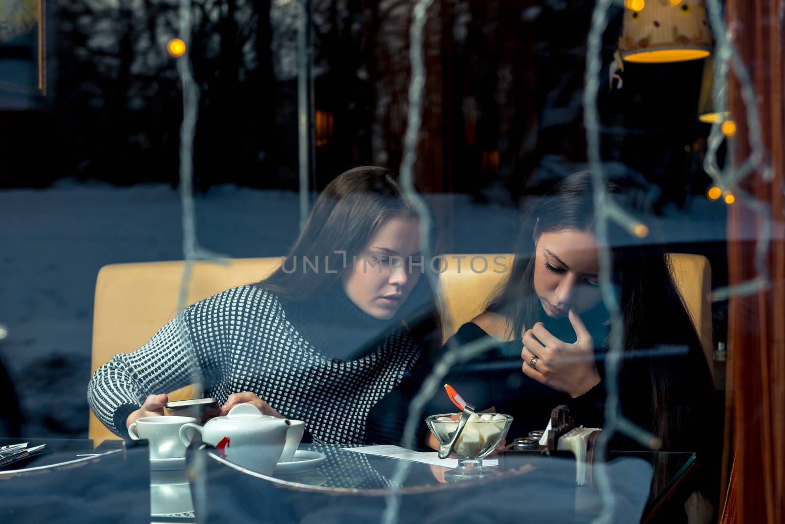 Communication of girlfriends, a meeting in a cafe, shooting behind a glass