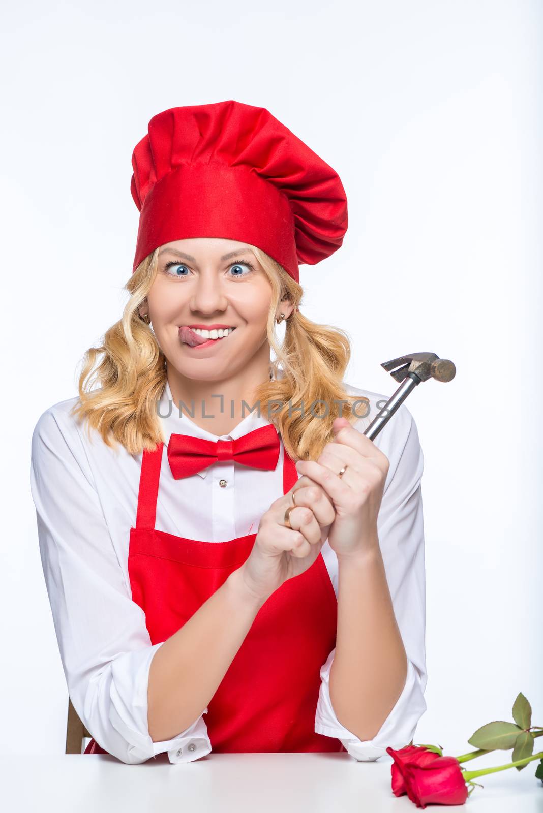 Crazy woman cook with hammer on white background isolated portrait