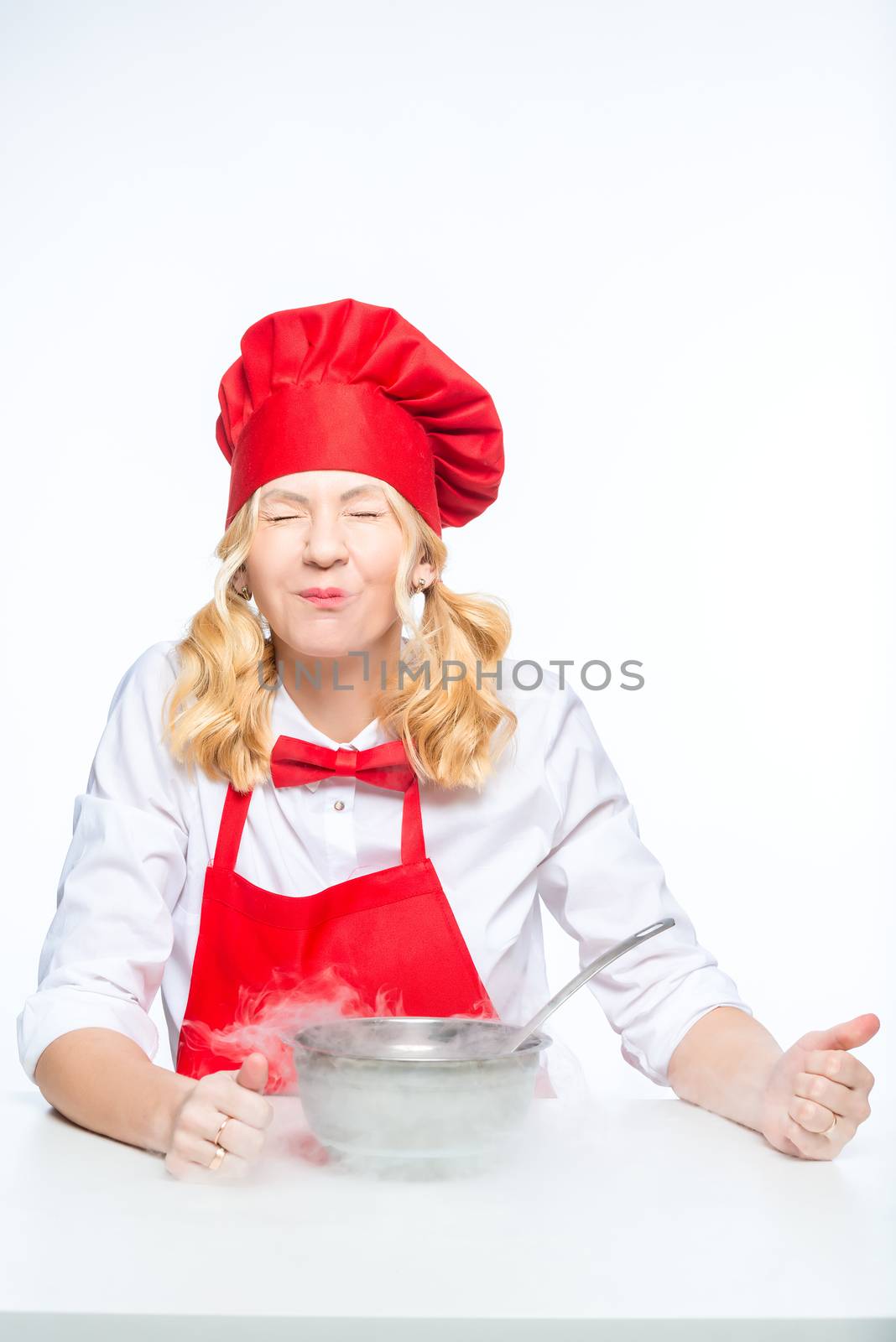 Cook in a red apron and hood conducts experiments with liquid nitrogen on a white background