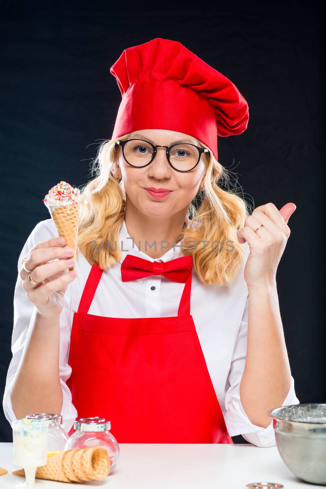 Smiling chef with homemade ice cream, portrait on black background isolated