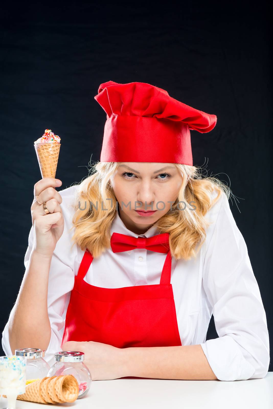 Aggressive cook with ice cream in hand, emotional portrait on black background